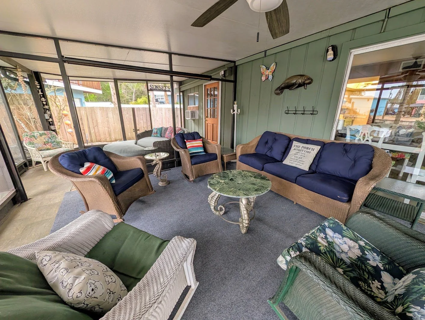 Enclosed screened porch with 4 oversized rocking chairs, couch, dinning for 6, and a day bed. 
