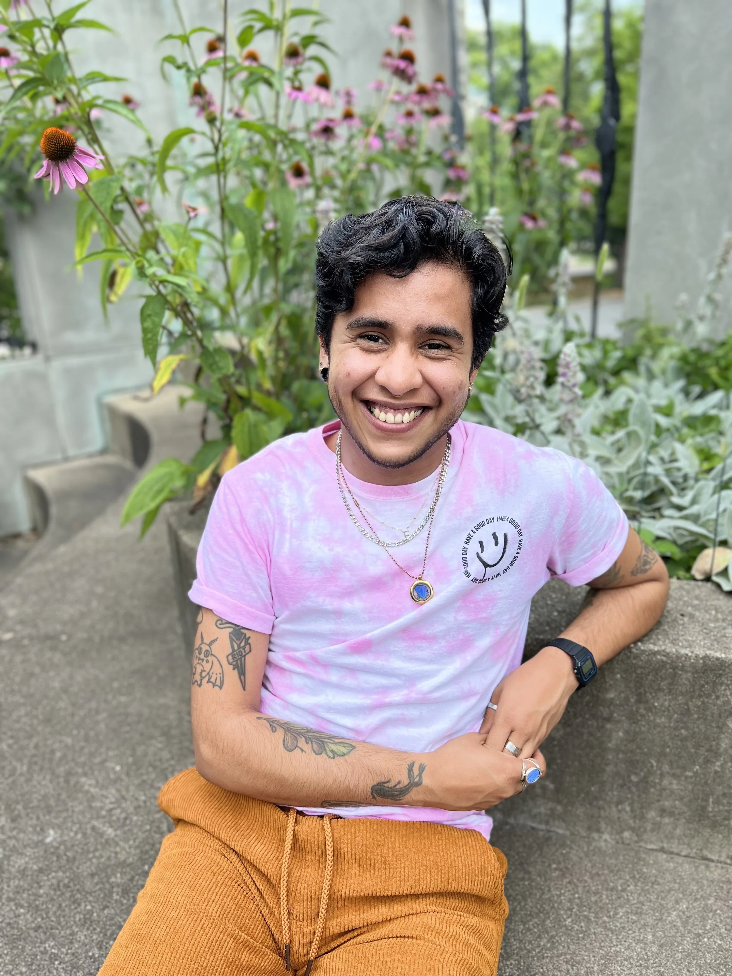 CAF’s Support Coordinator Ezra smiling and wearing a pink tie-dye shirt