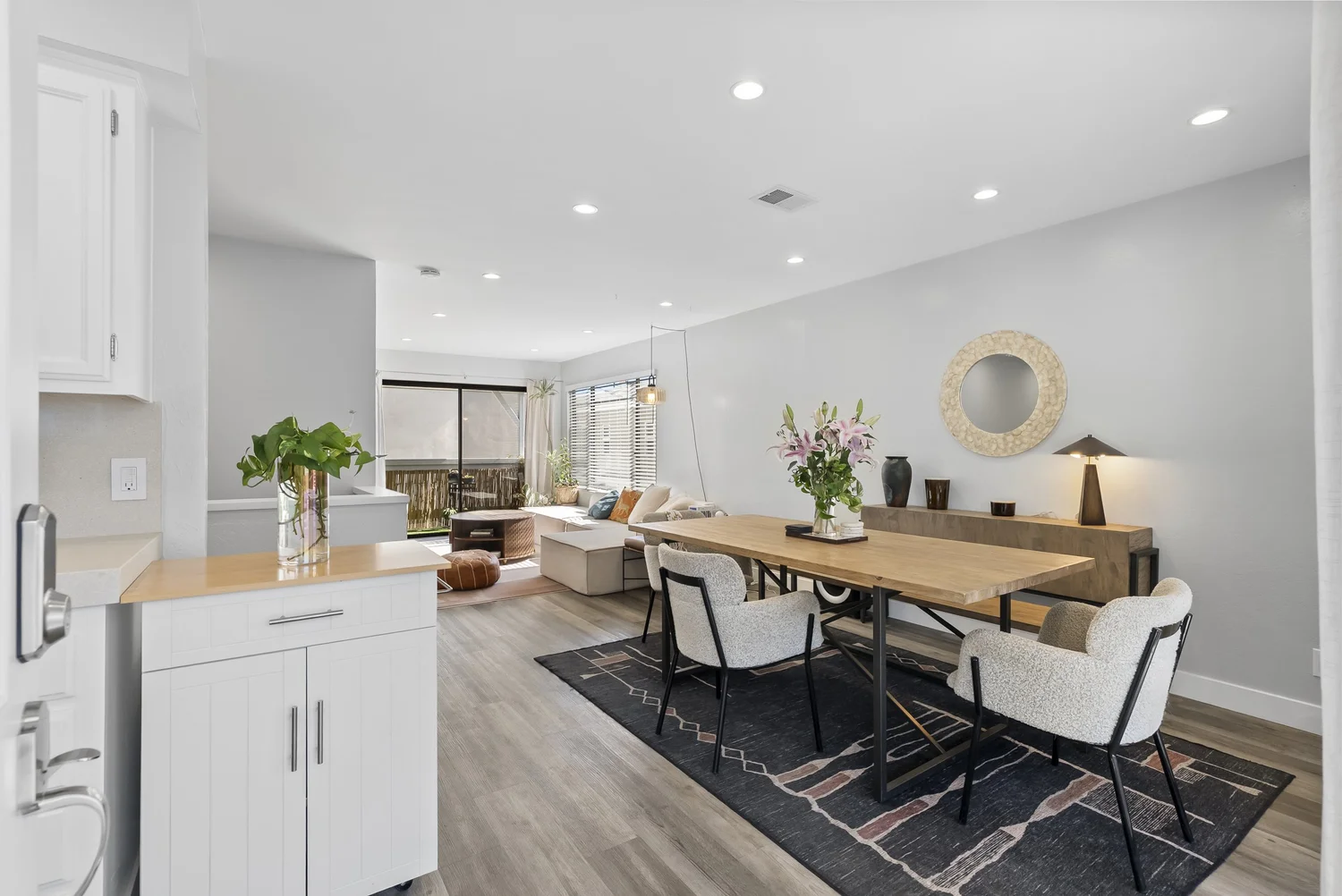 Rear home open living and dining area with white kitchen