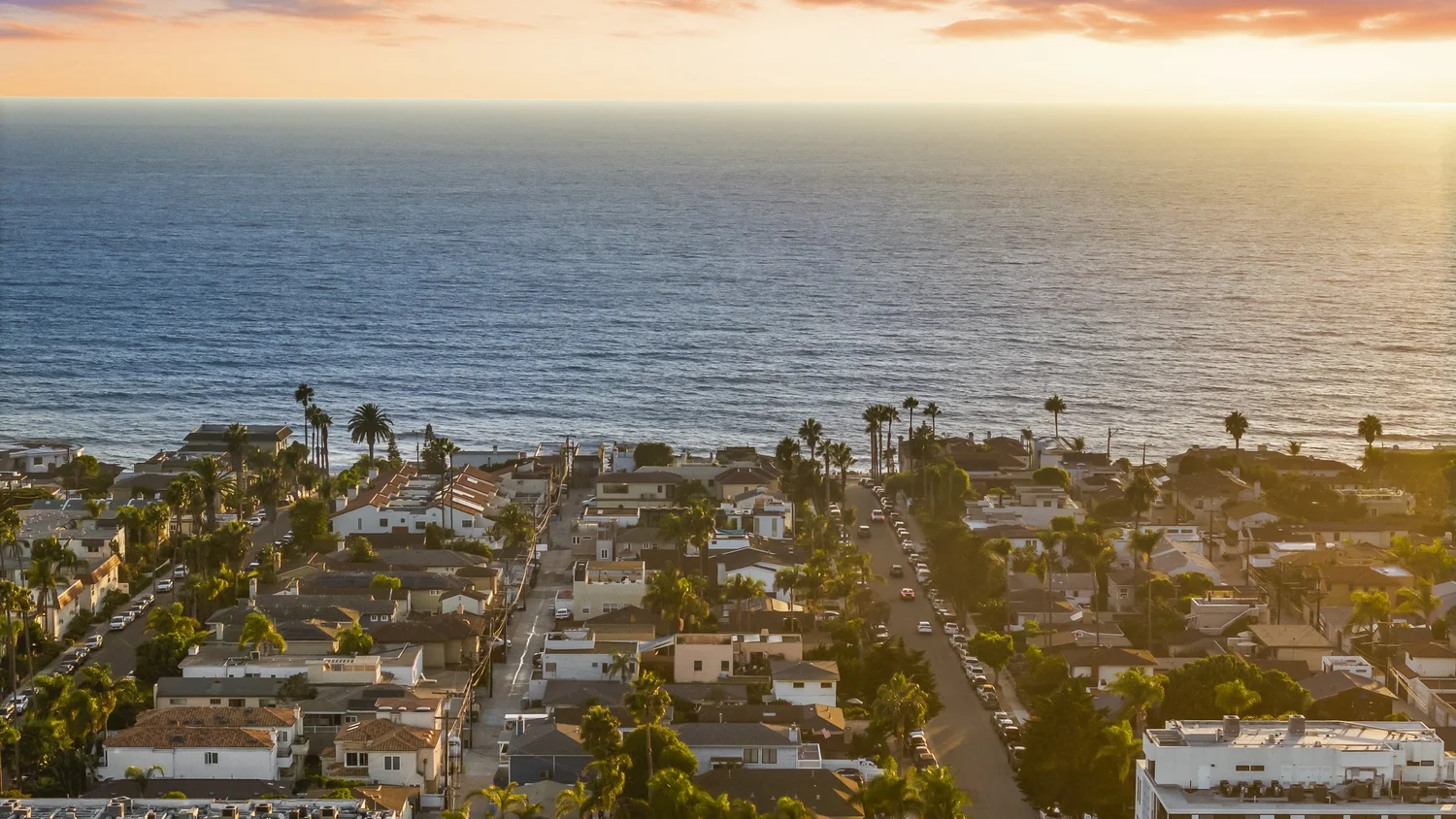 Sunset aerial of La Jolla Barber Tract rooftops and the Pacific Ocean