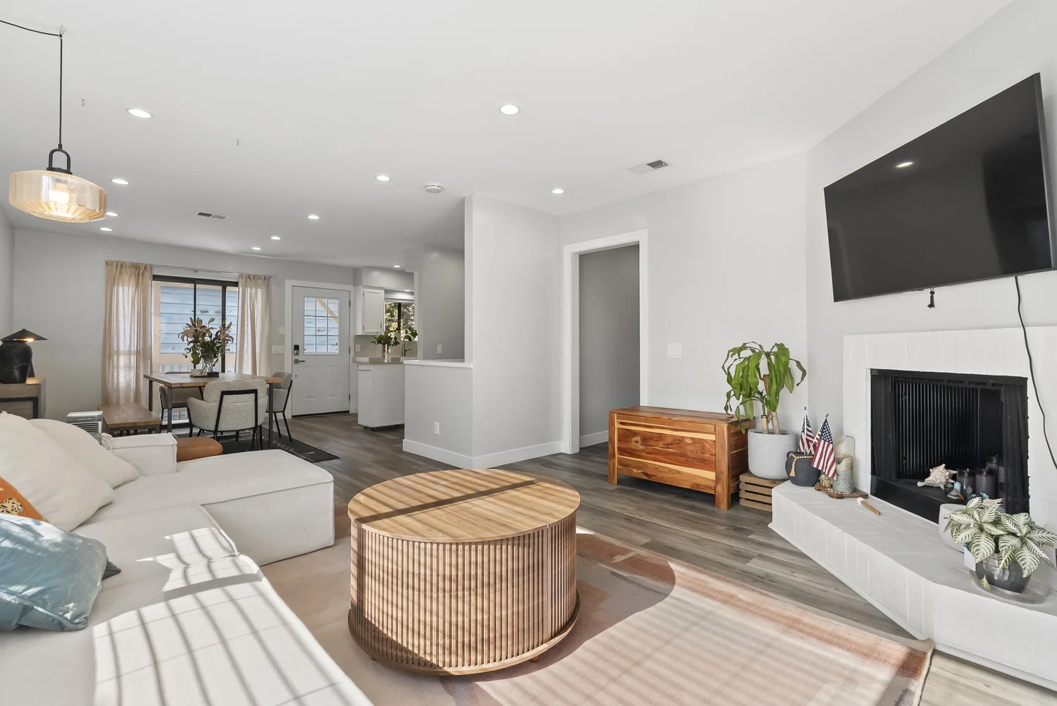 Living room with white fireplace, sectional sofa and wood floors