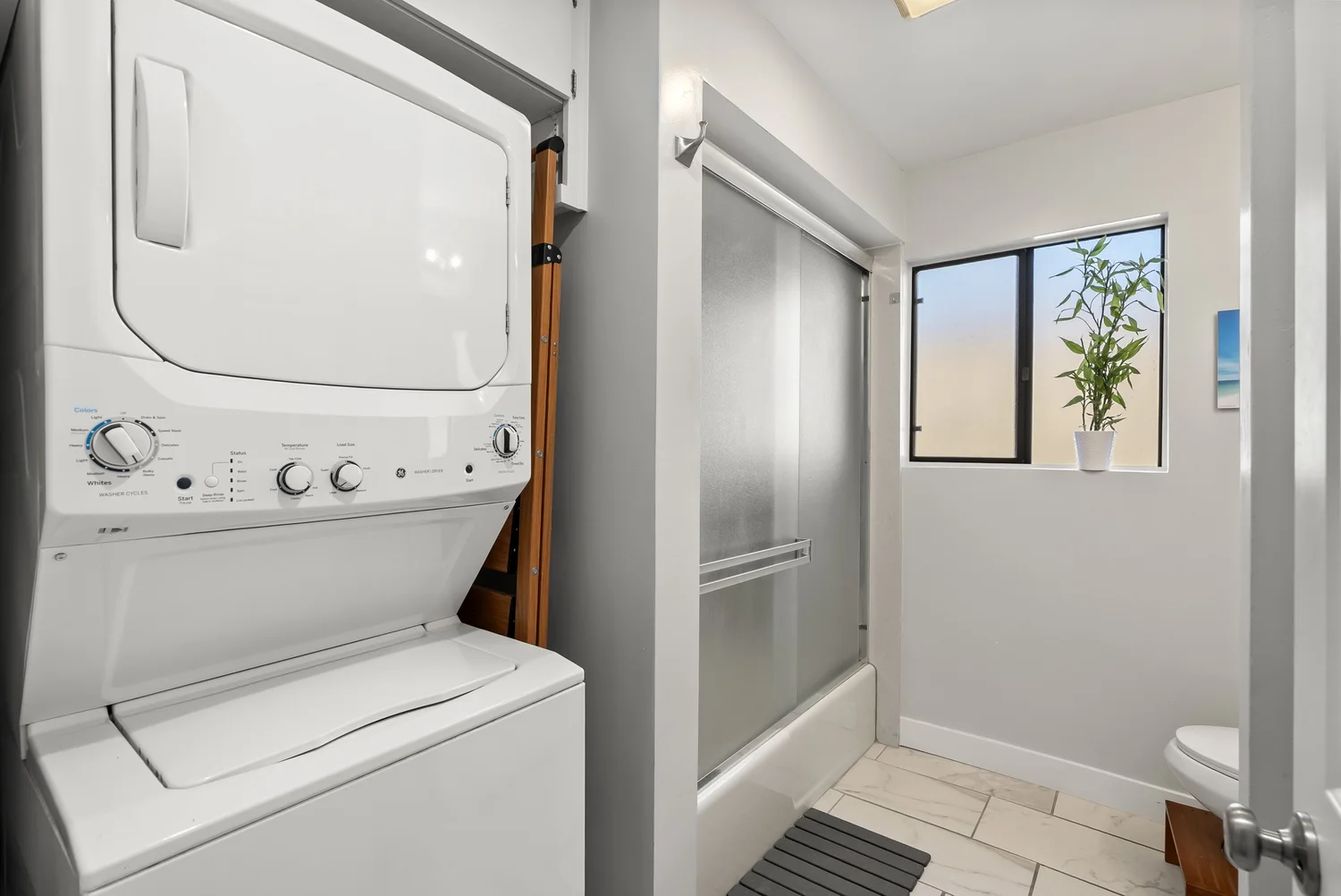 Stacked washer and dryer next to the bathroom