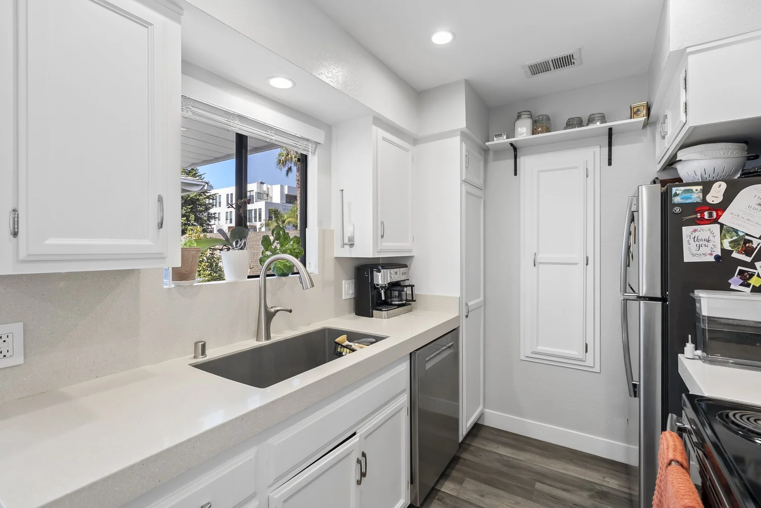 Kitchen sink with white counters and dishwasher