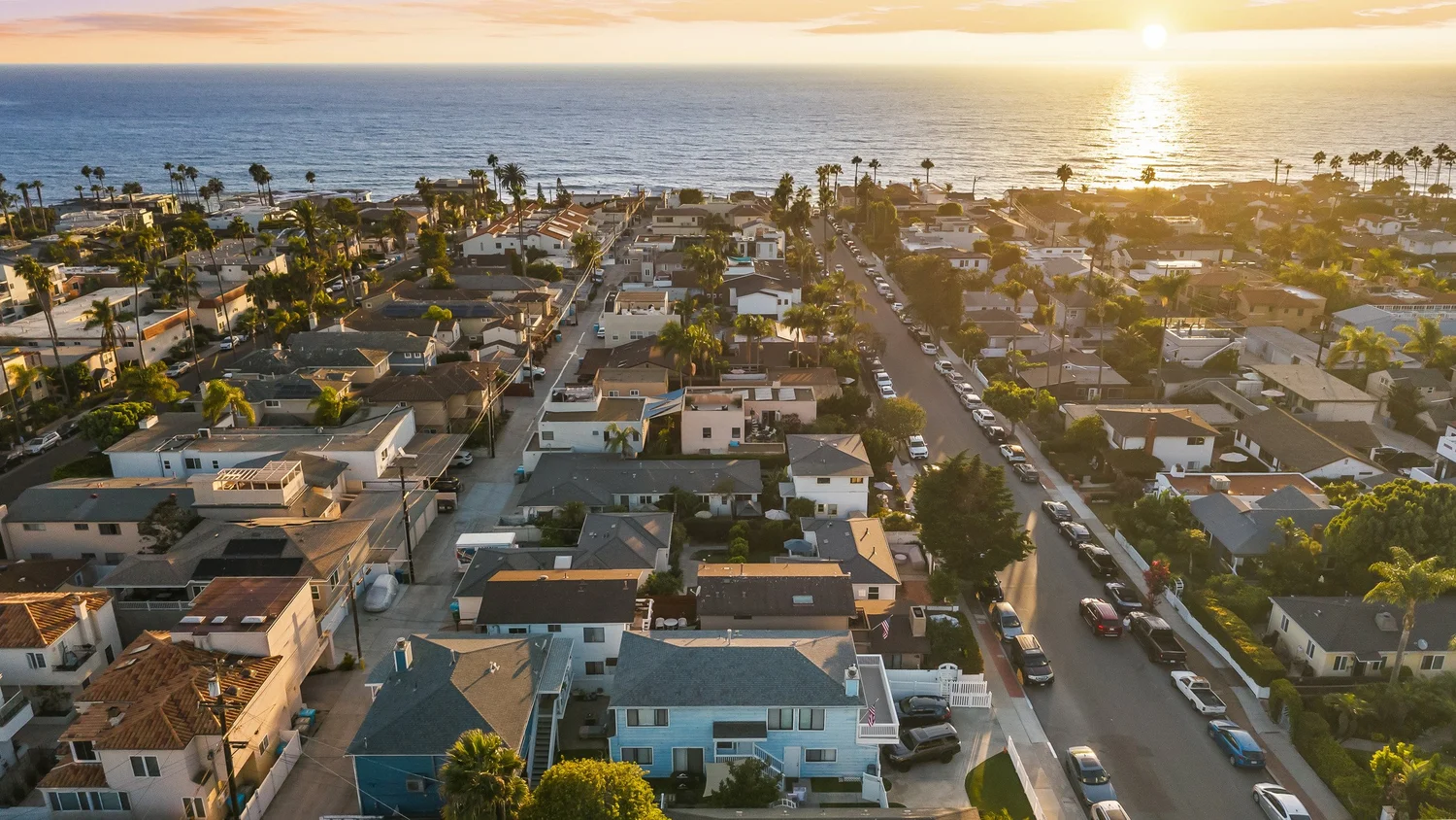 Aerial looking down a Barber Tract street toward the ocean at sunset in La Jolla