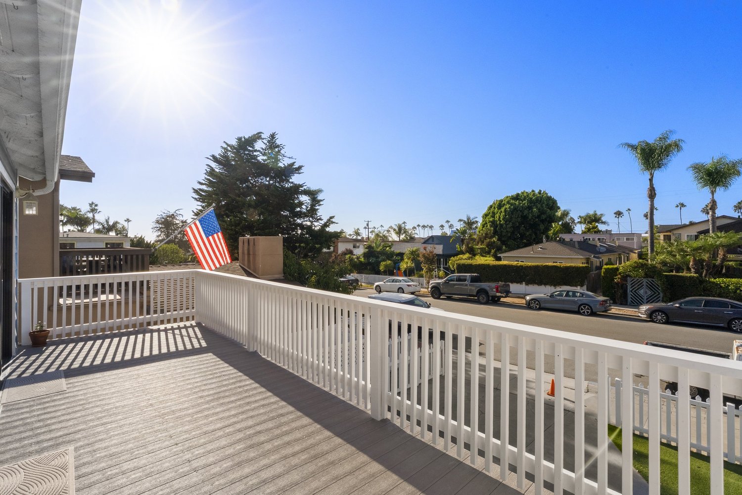 Balcony with white railing and palm trees