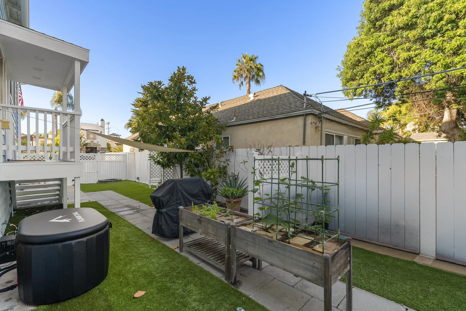 Back yard with lawn, raised garden beds and a grill