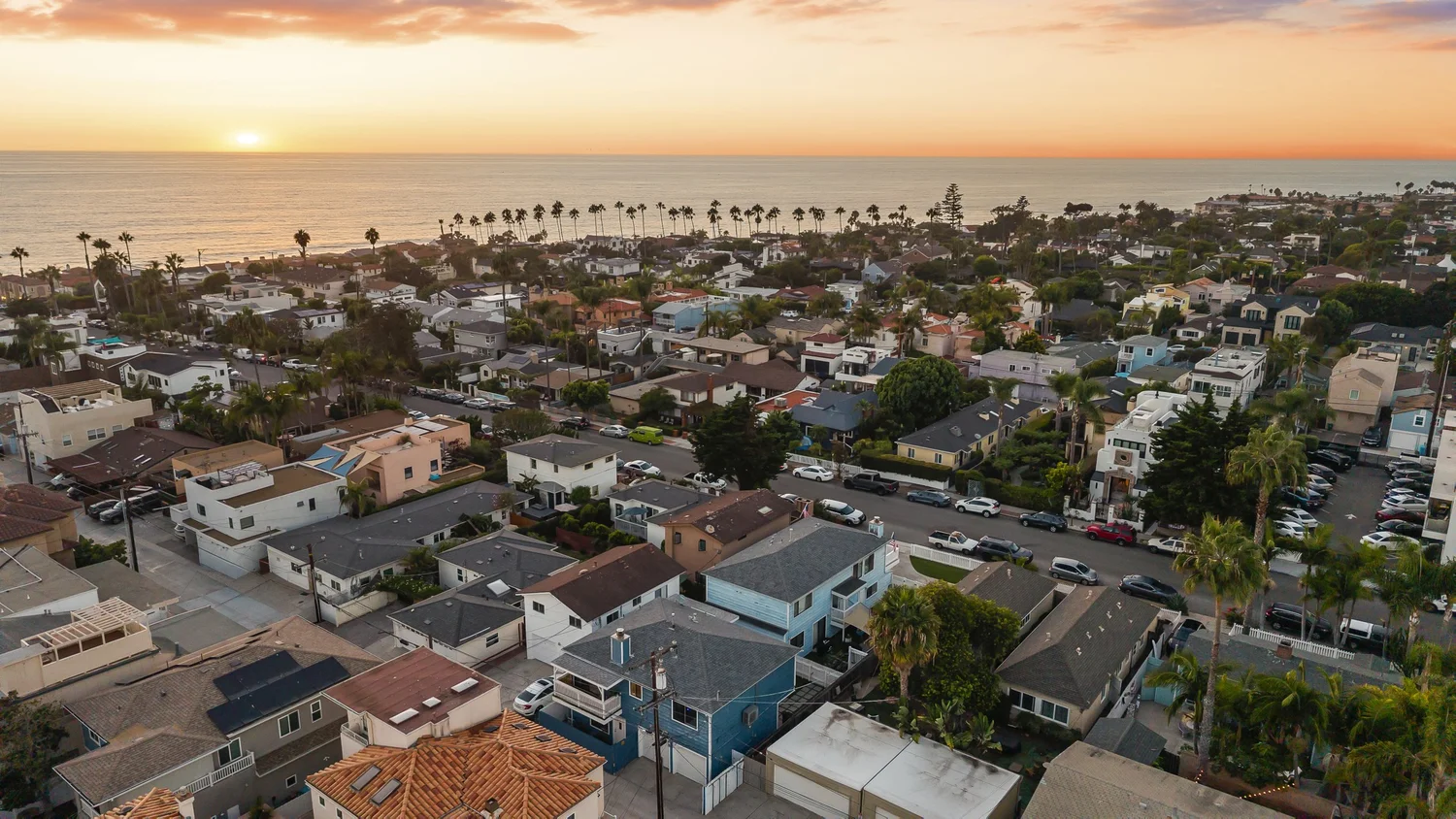 Aerial at sunset over the neighborhood toward the Pacific