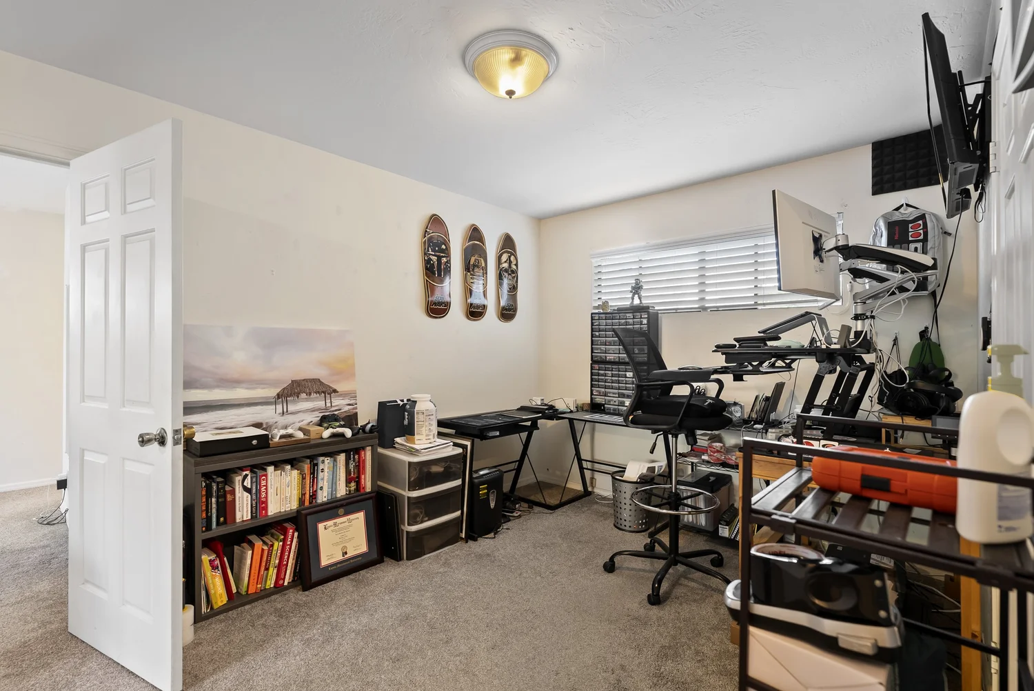Bedroom used as a home office with desk and bookshelves