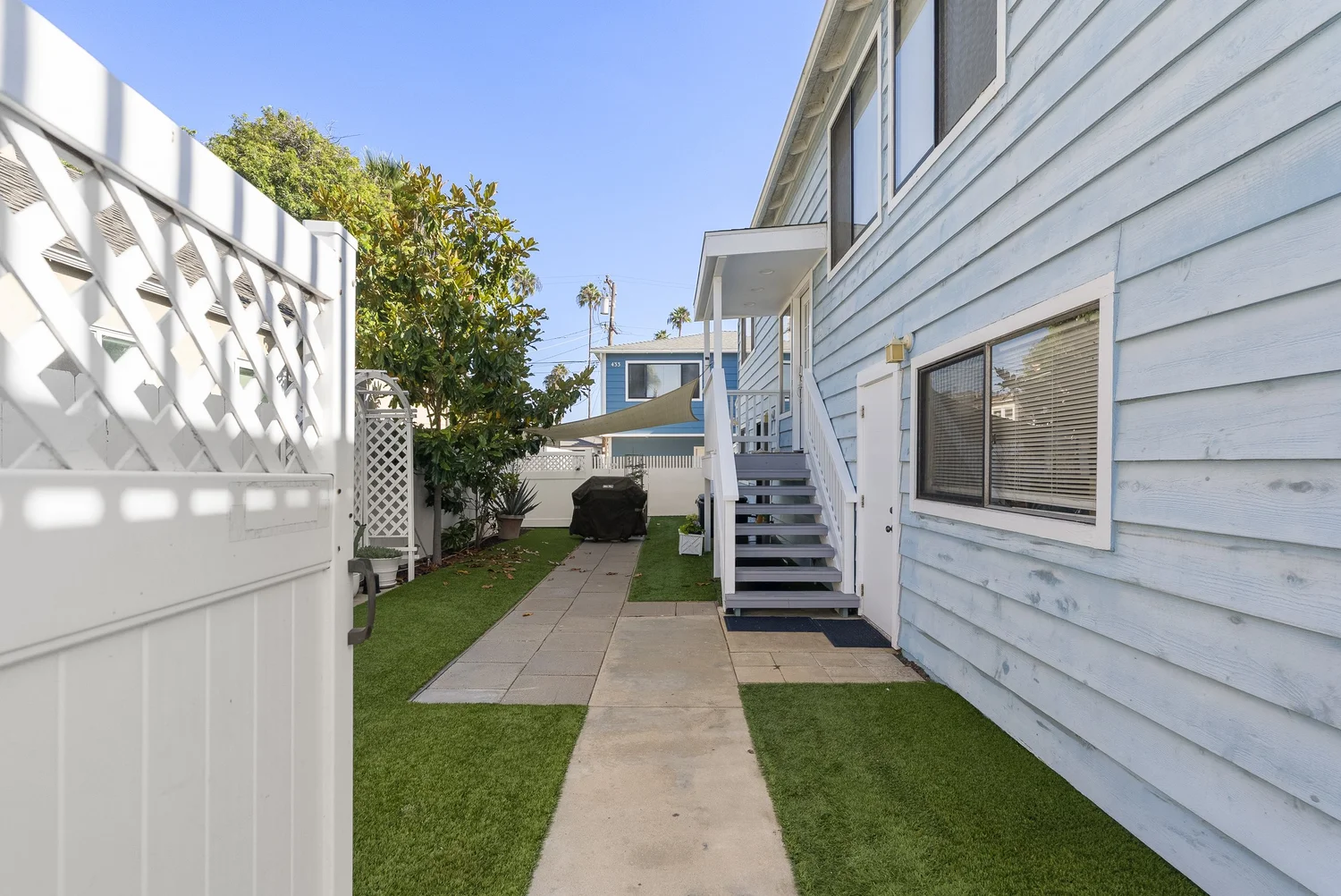 Side yard with lawn, paver walkway and exterior stairs