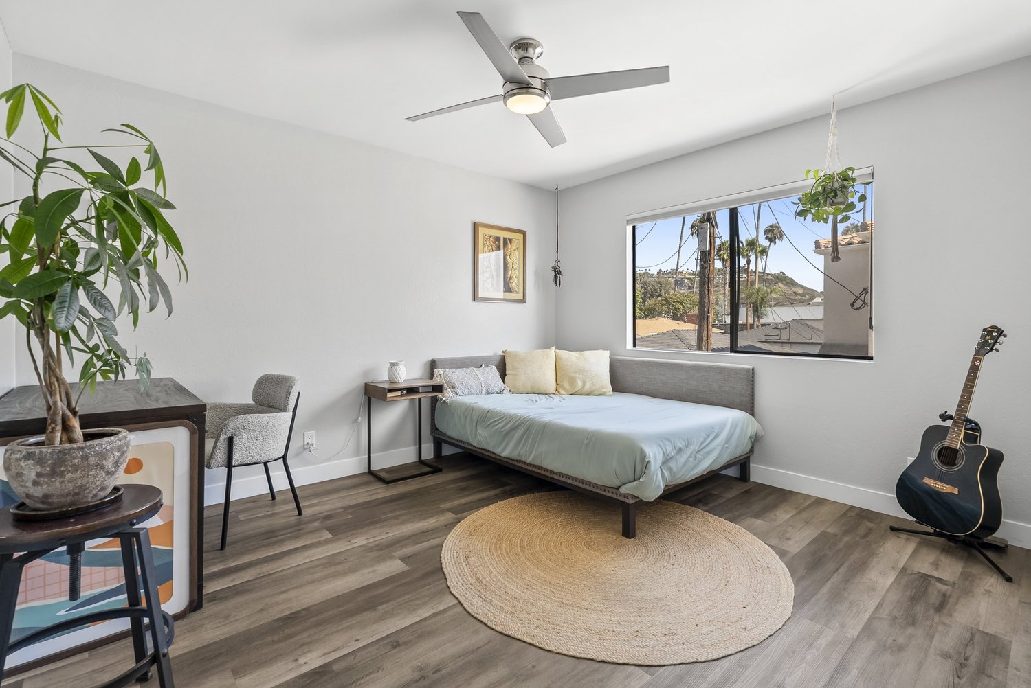 Bedroom with bed, round rug and ceiling fan