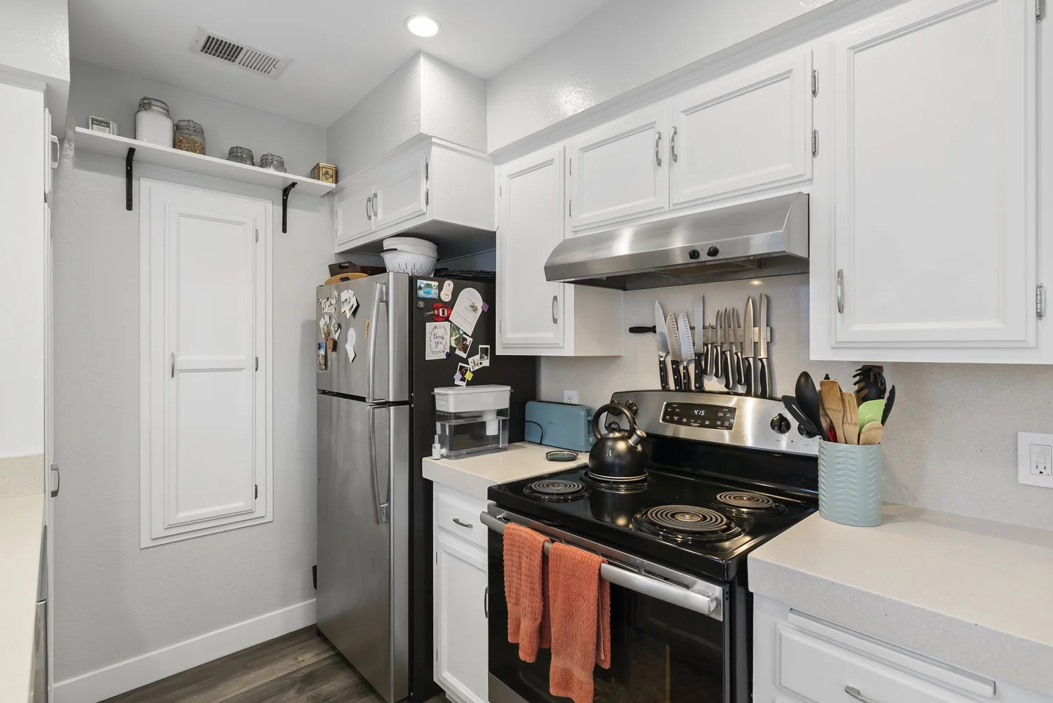 Kitchen with stainless range and open shelving