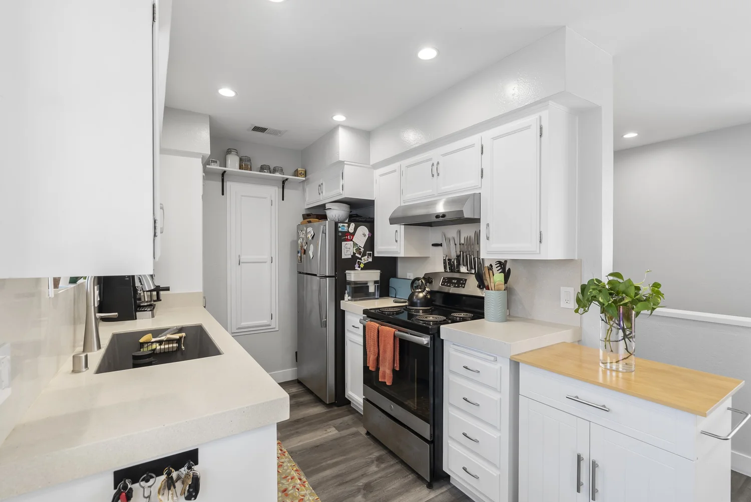 White kitchen with stainless range and refrigerator