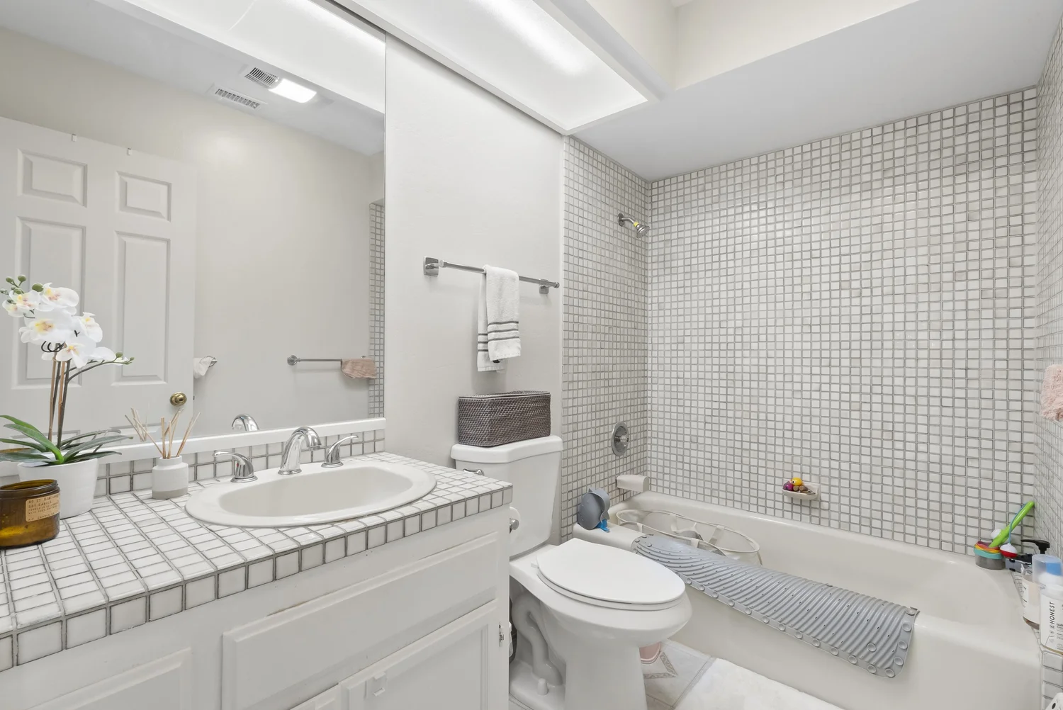 Bathroom with tub, tiled surround and vanity