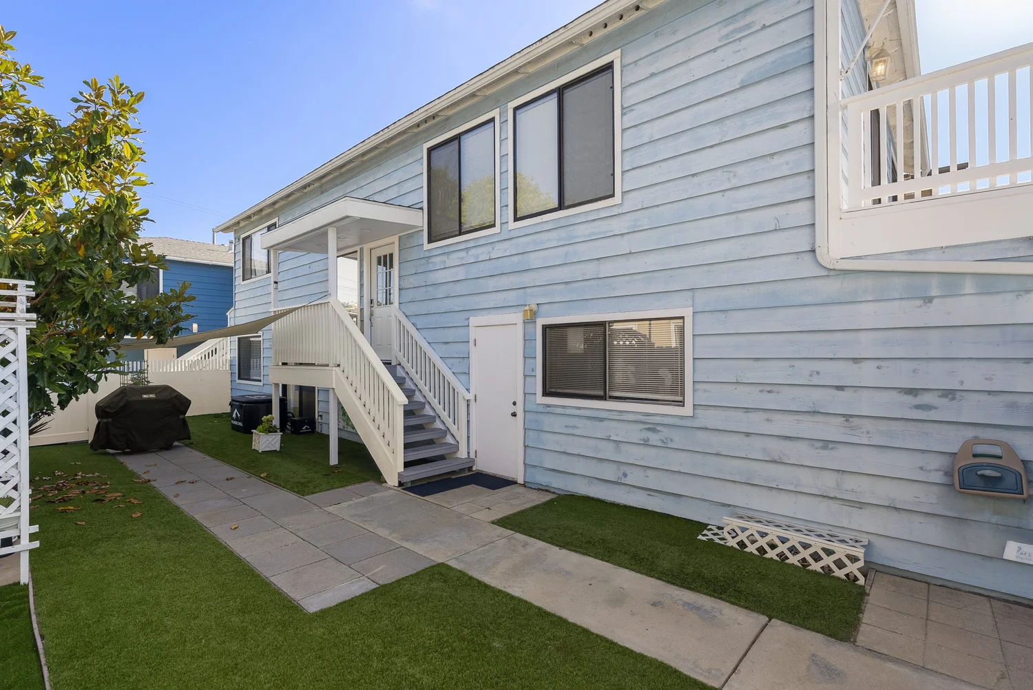 Side yard lawn and exterior staircase along the front home