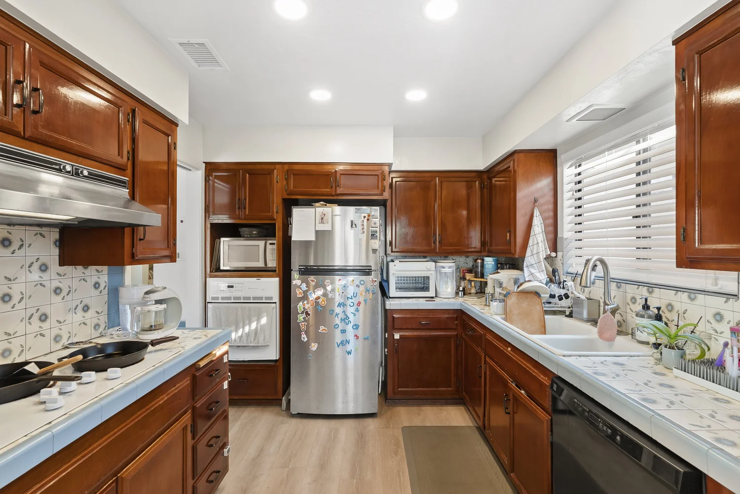 Front home kitchen with wood cabinets and stainless refrigerator
