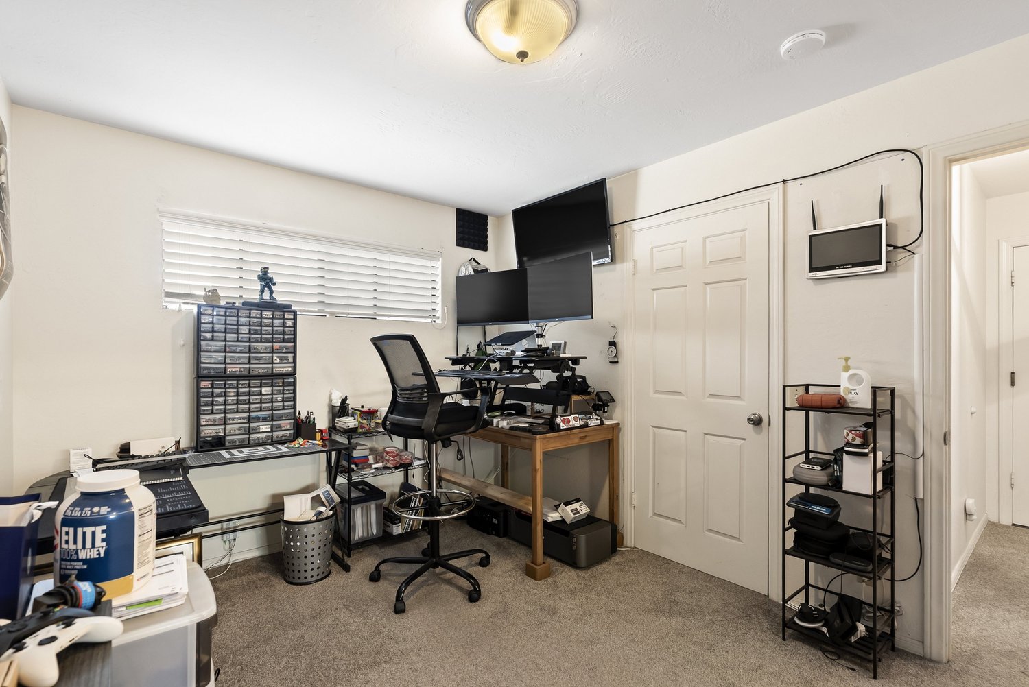Bedroom used as a home office with desk and storage