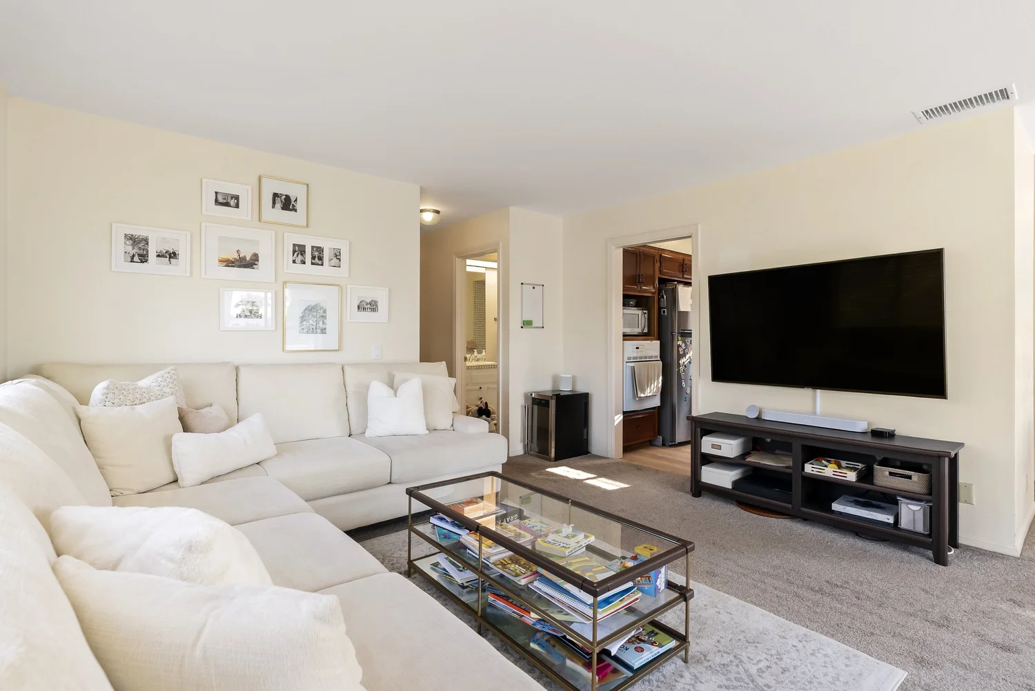 Living room looking toward the hallway, with sectional sofa and TV