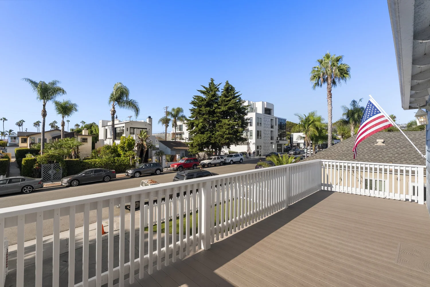Front home balcony deck with white railing overlooking the street