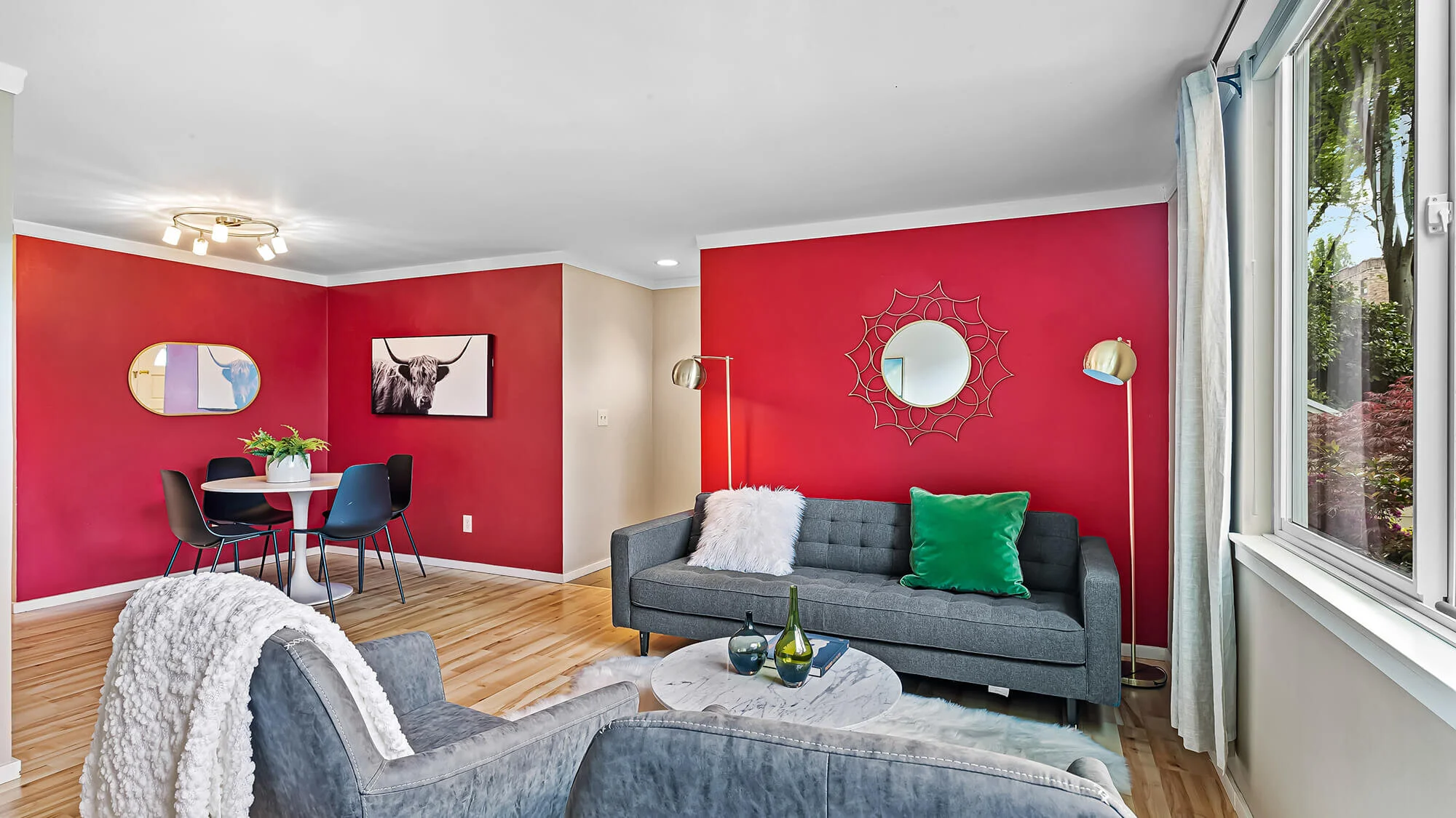 interior of living room with hardwood floors, large window, couch and chairs