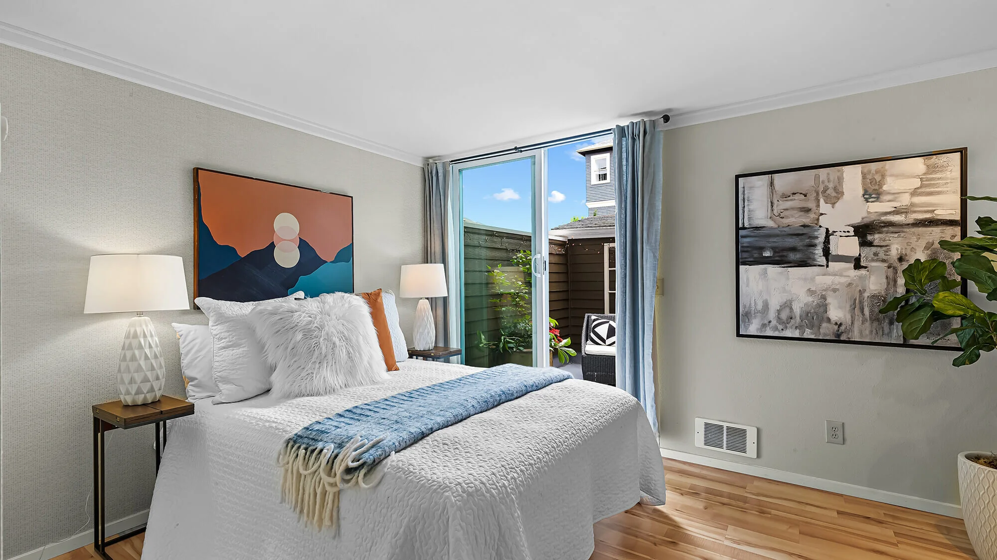 interior of bedroom with hardwood floors, sliding glass door, and queen bed