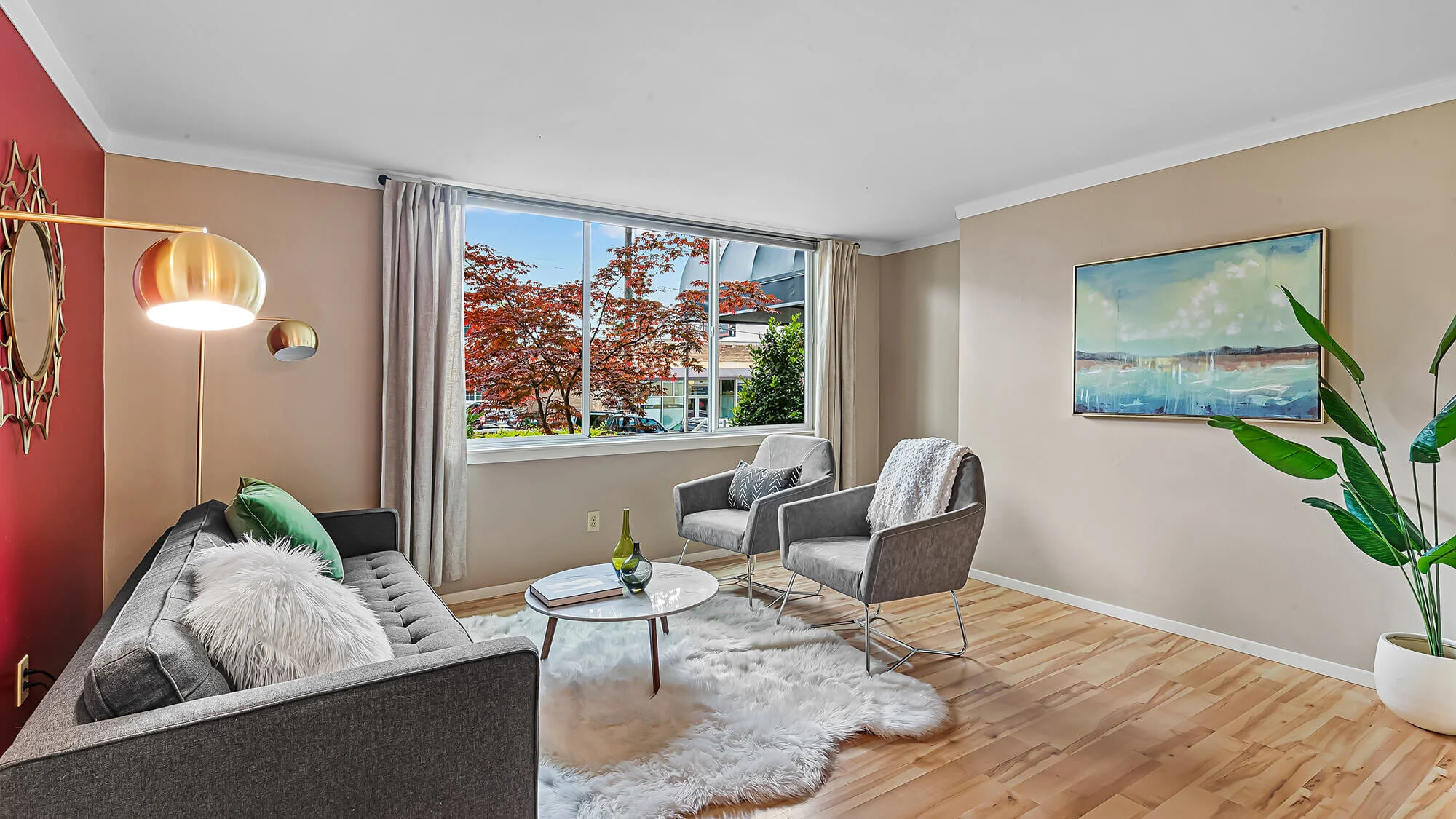 interior of living room with hardwood floors, large window, couch and chairs