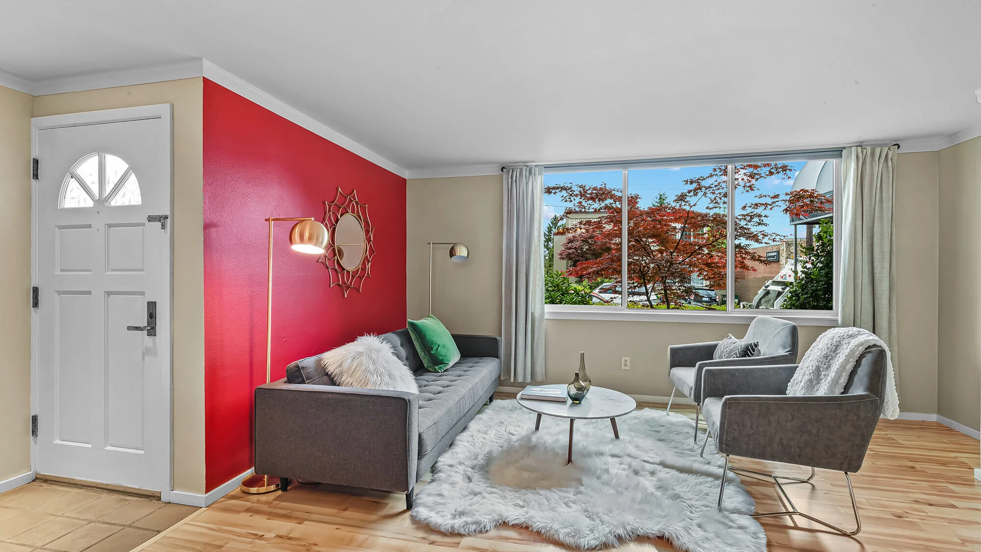 interior of living room with hardwood floors, large window, couch and chairs