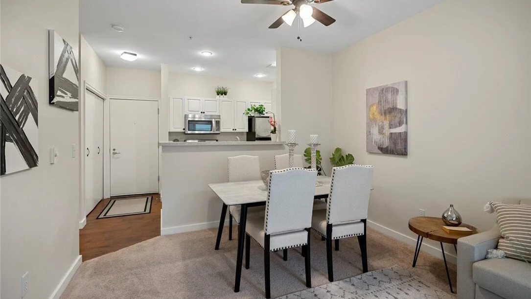 interior of dining room and second living room with dining table, couch, chair, and large window 