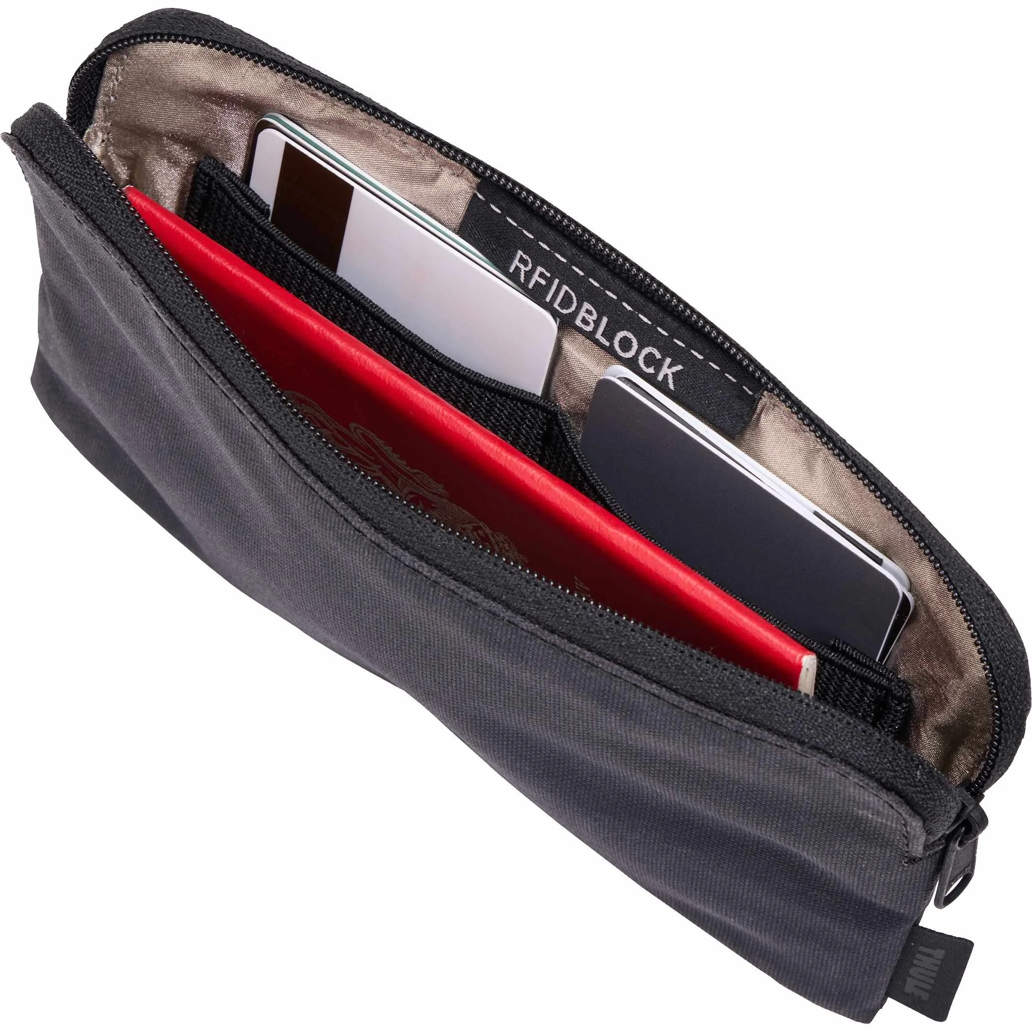Open Thule Aion travel organizer holding a passport, documents and a red notebook
