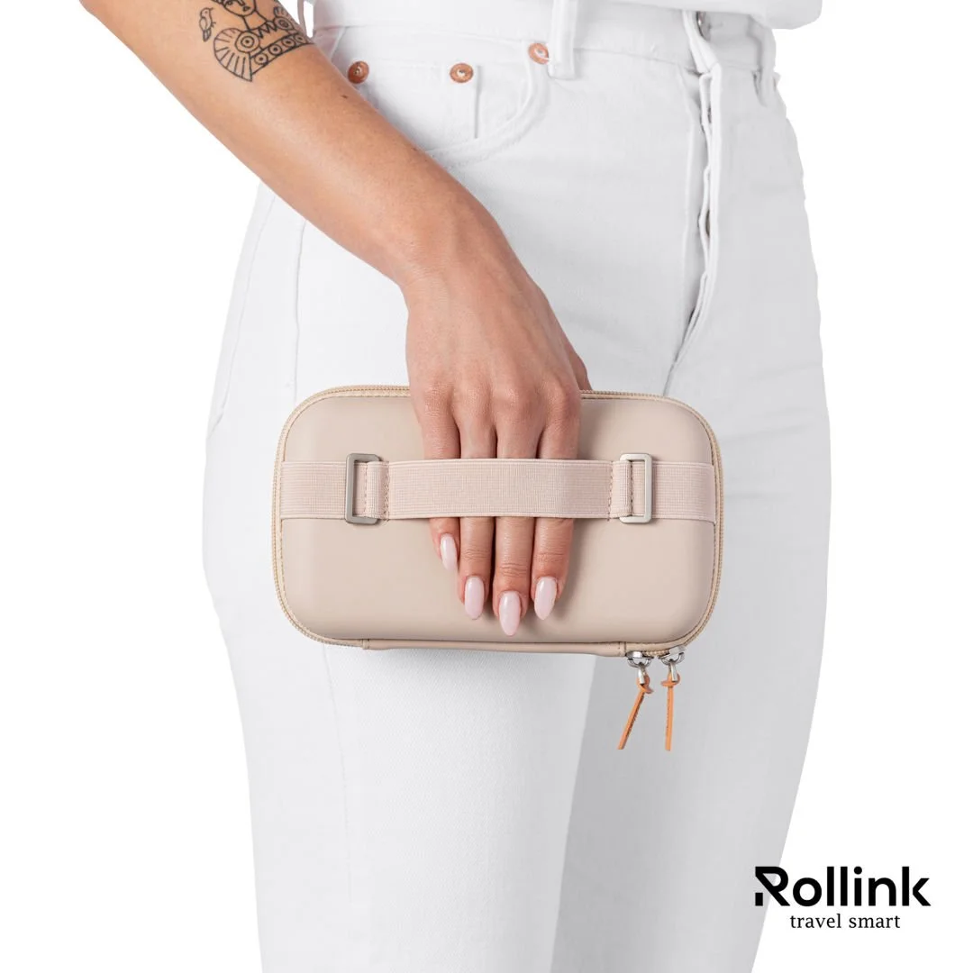 Woman holding a beige Rollink Tour Mini Bag by the hand strap