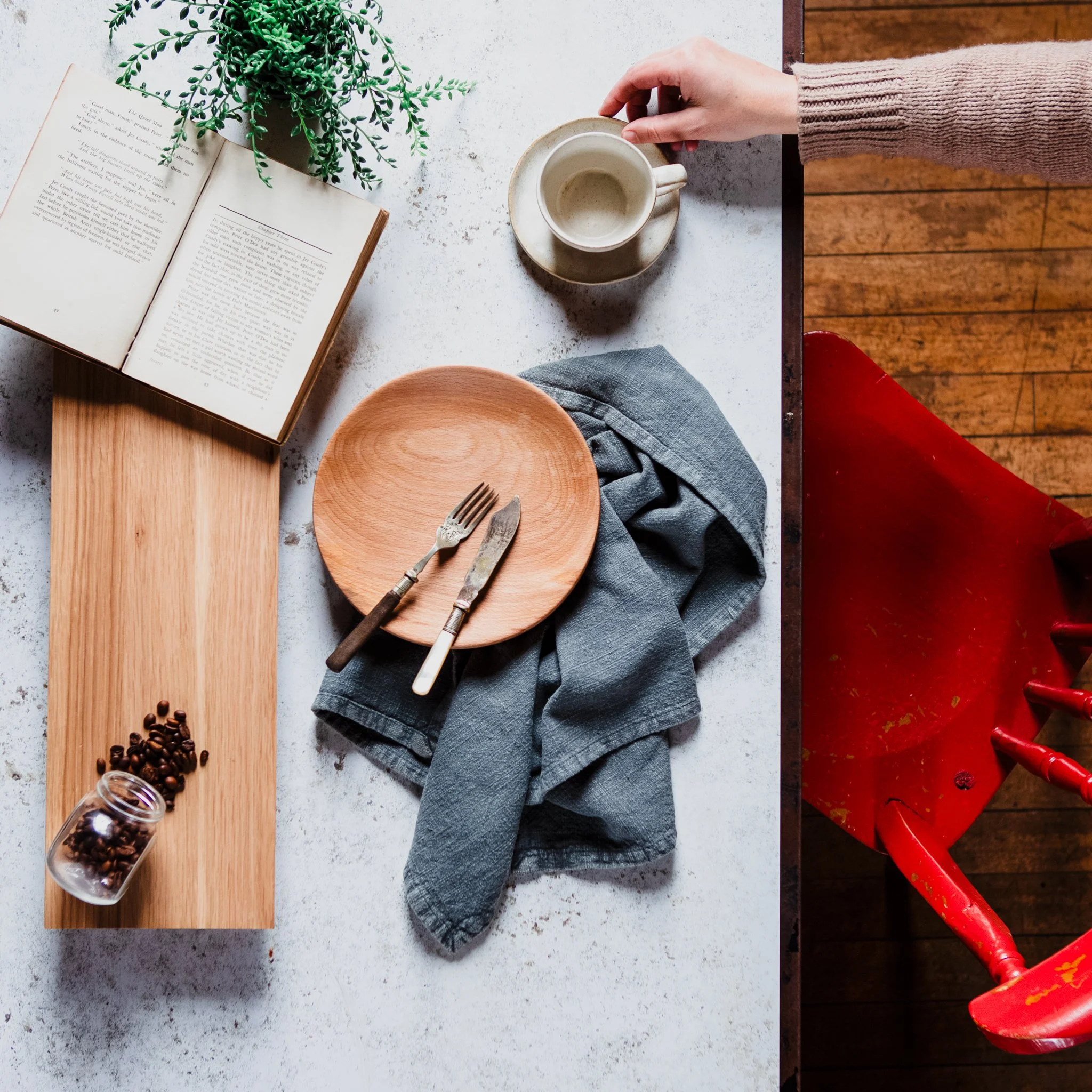 Notebook, cup and styling materials laid out on a table while planning product photographs.