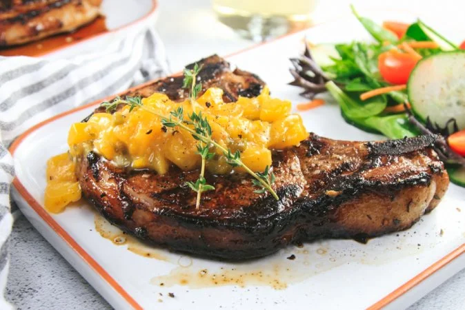Marinated Bone-in Pork Chops on the Grill with a Spicy Peach Sauce