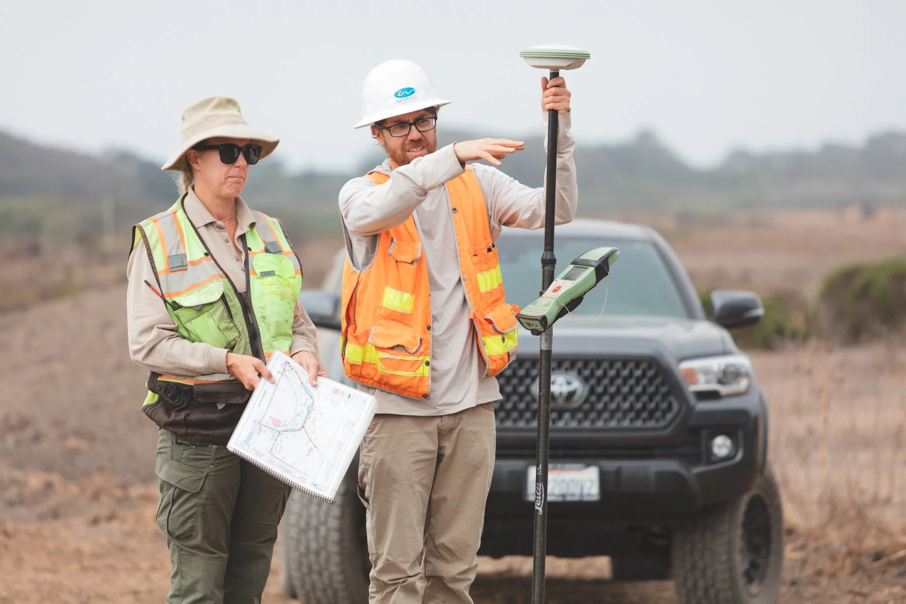two team members looking at plans
