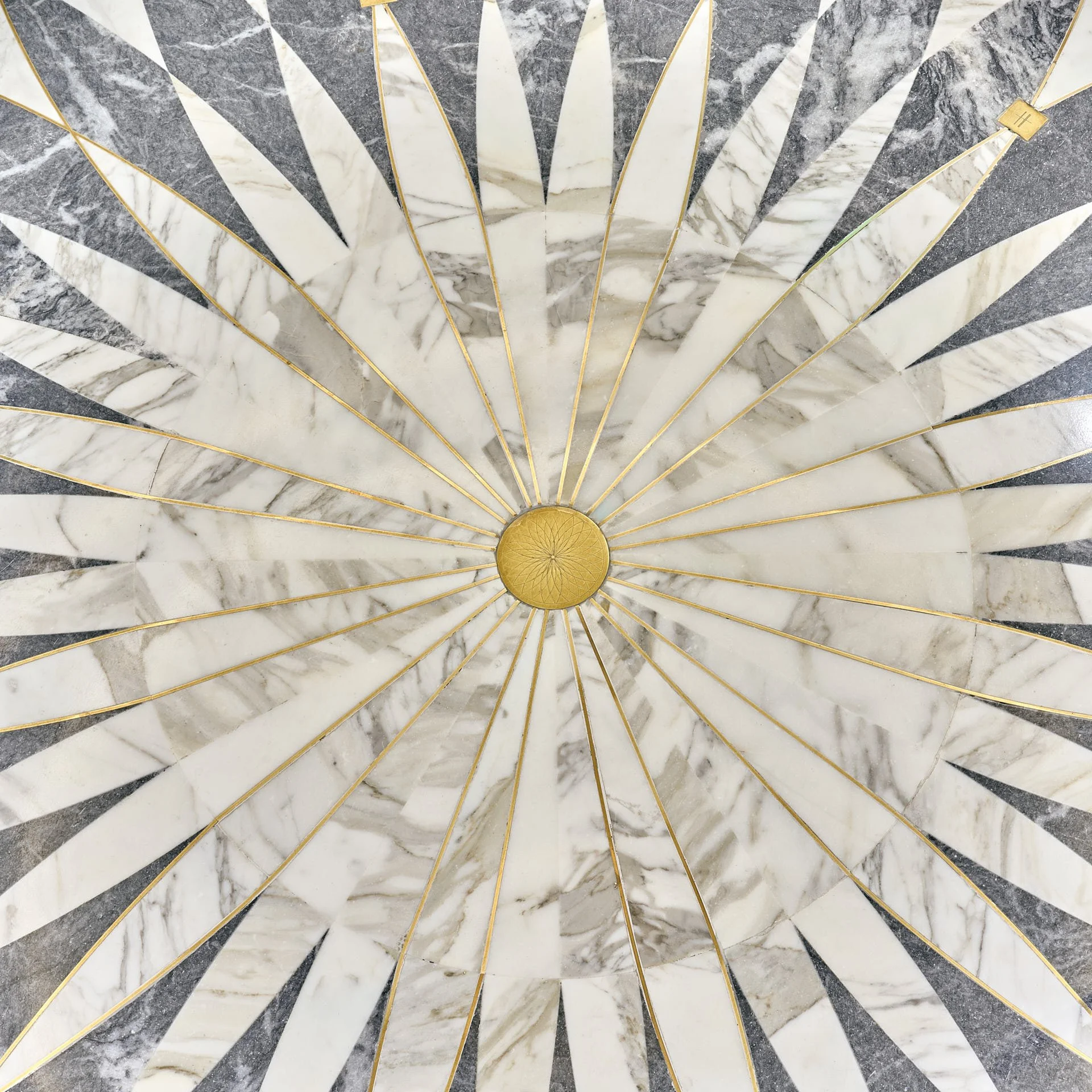 Overhead detail of a radial stone floor with a brass centre, fine radiating brass lines and alternating pale and blue-grey stone. Fabrication and installation by stoneCIRCLE - photo Marco Joe Fazio Studio.