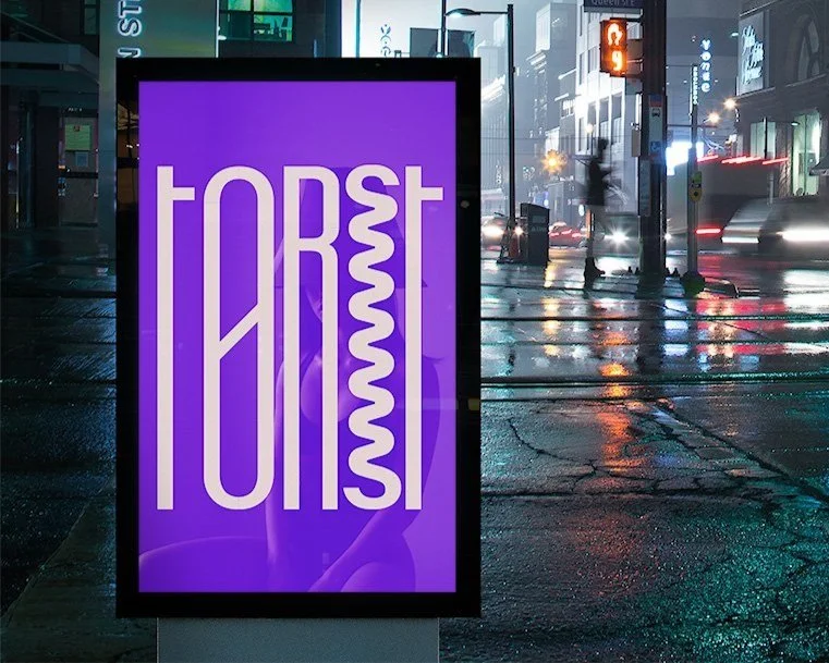 Lilla reklameplakat i en bygate, med teksten 'TØRST' i hvitt.