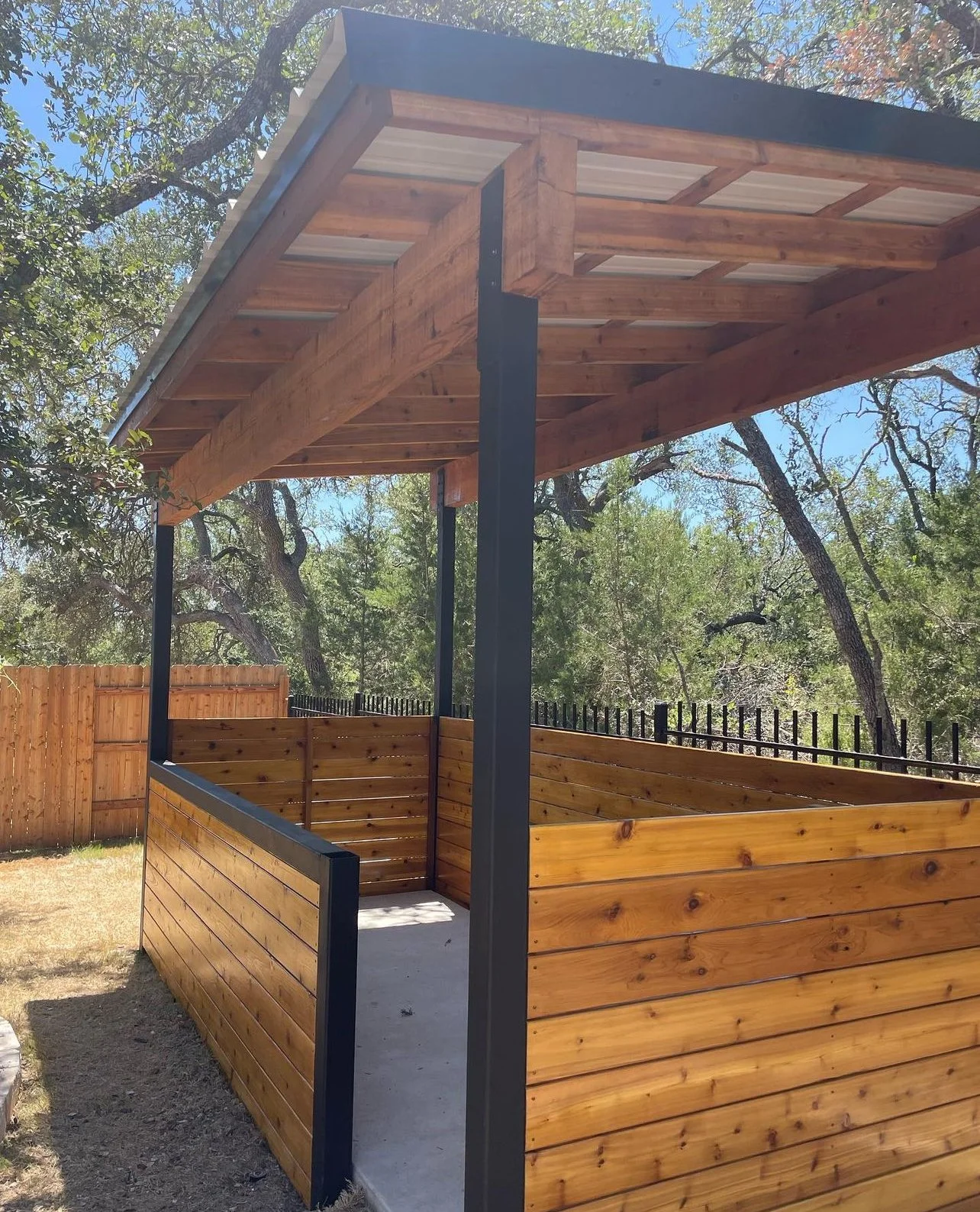 Covered outdoor area with steel posts and wood framing.