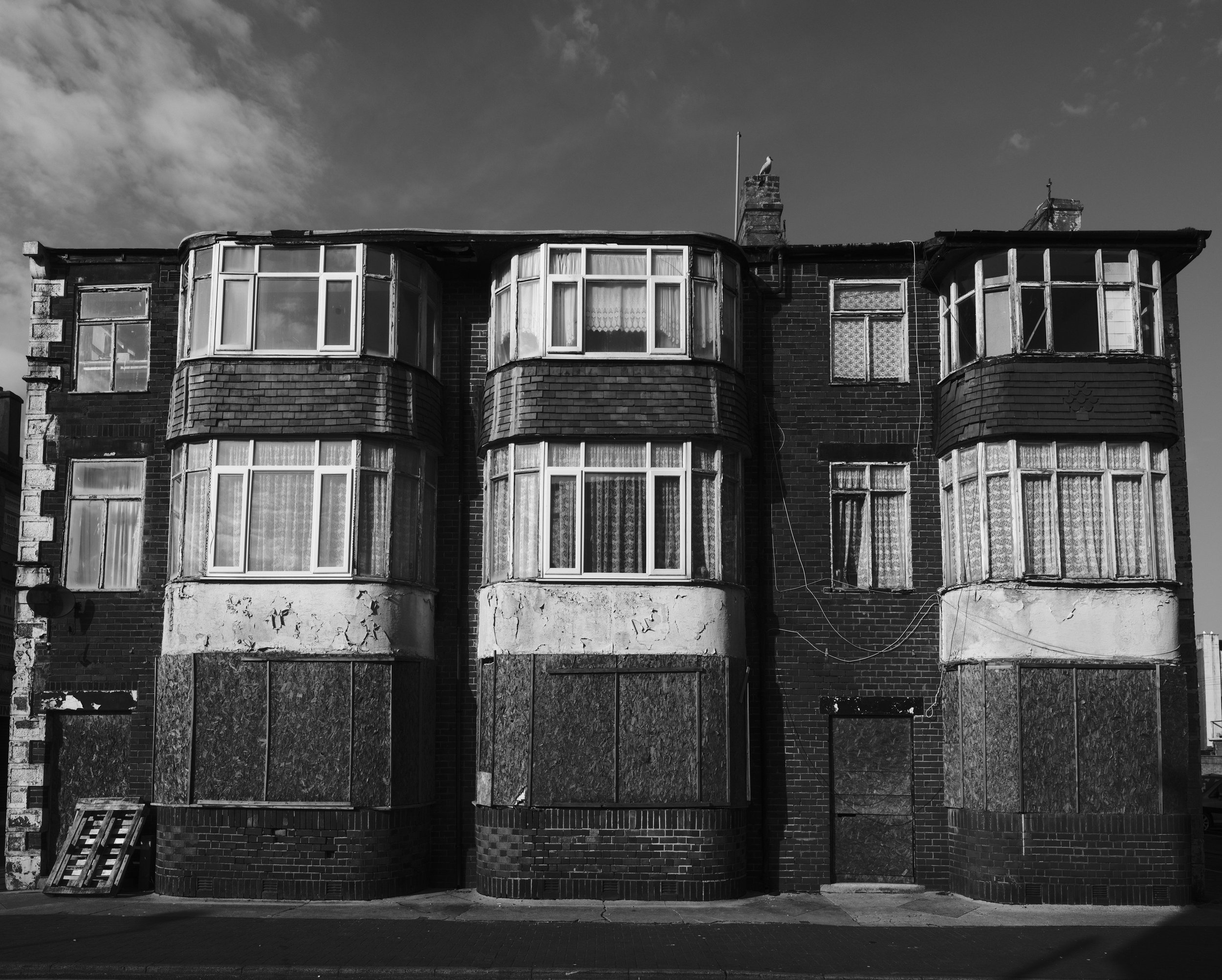 A block behind the promenade the boarded up houses and broken windows begin.