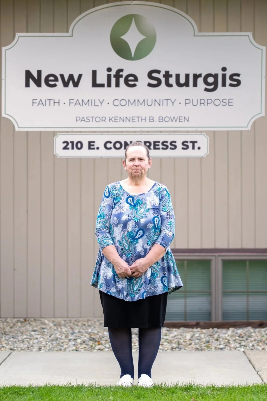 Person standing in front of Potter's House Church sign.