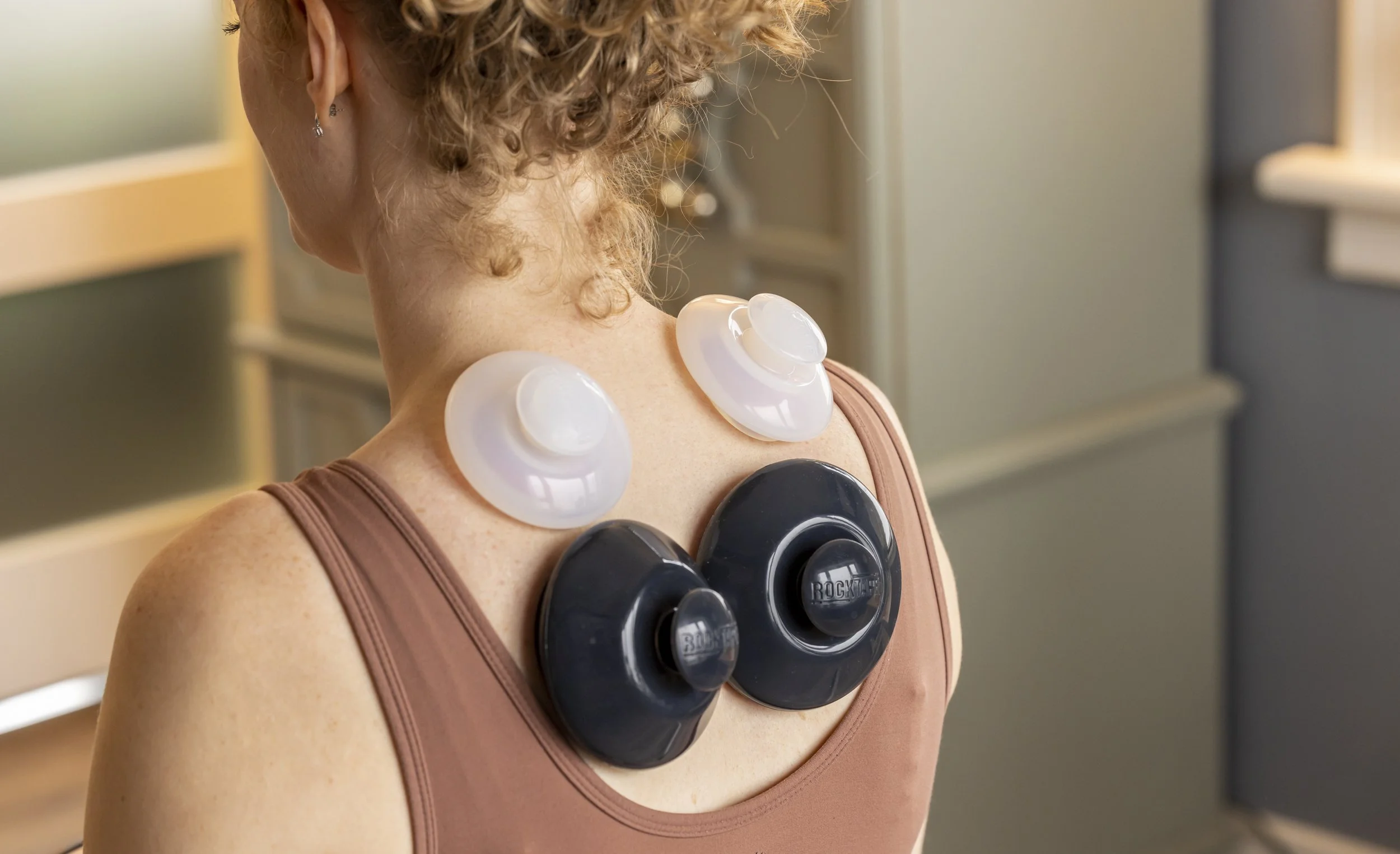 Port Elgin Chiropractor Dr. Burns is pictured. Silicone cups are placed on the patient's back for cupping therapy to improve range of motion and decrease pain.