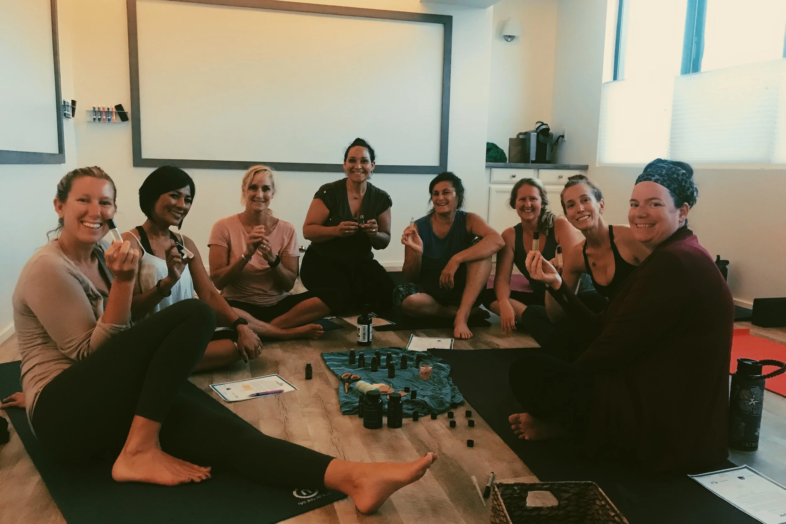 Women gathered in a wellness space, learning about essential oils