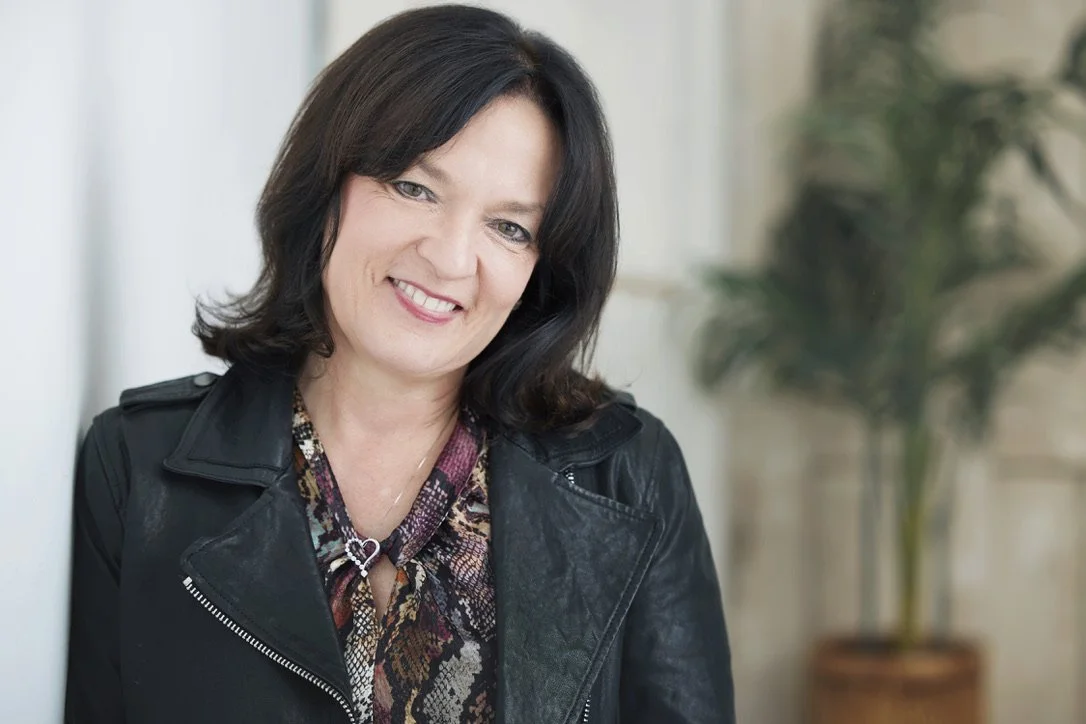 Diana Vazquez-Douglas, author and systems thinker, wearing a black leather jacket.