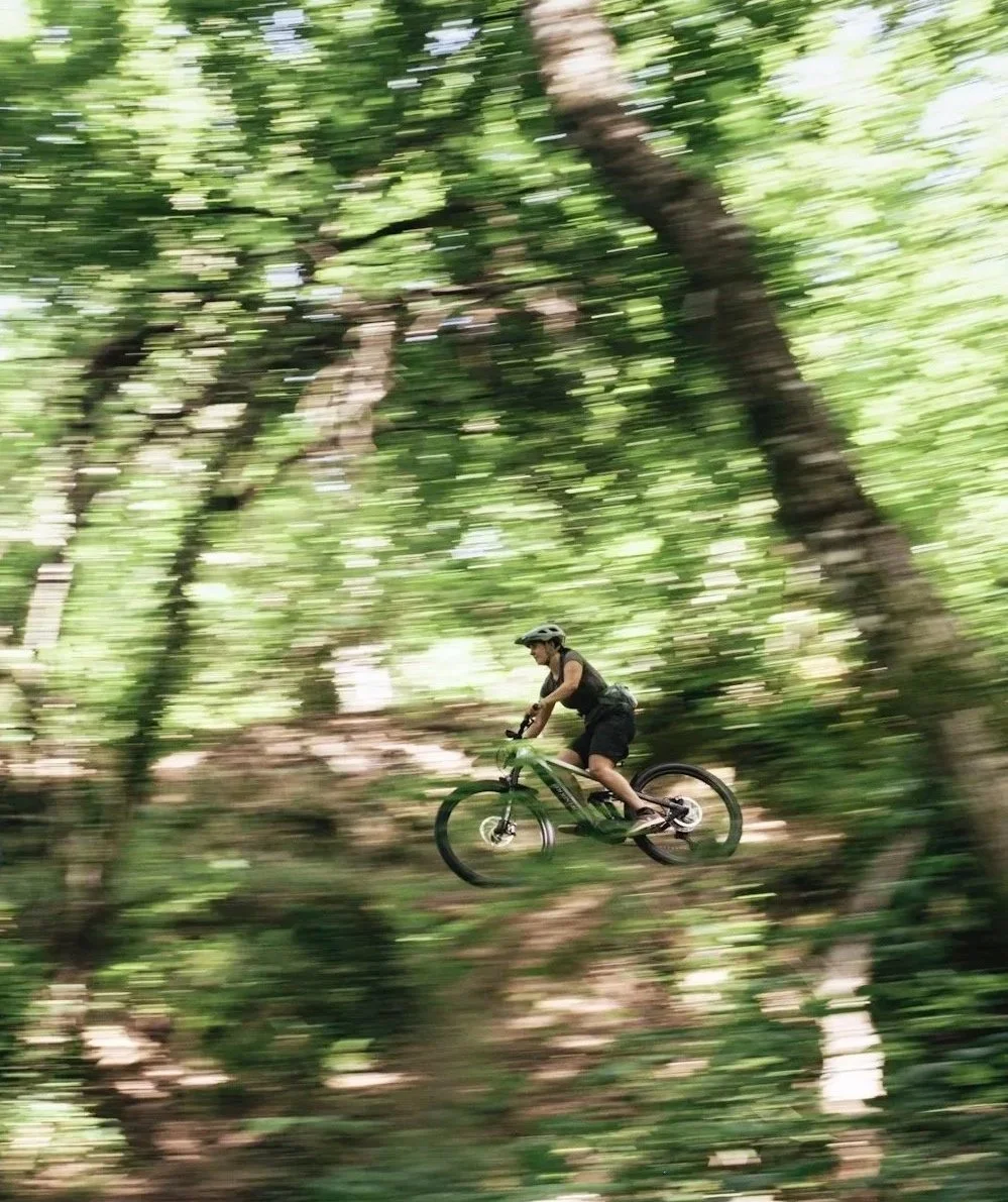 Woman riding a mountain bike fast in a forest