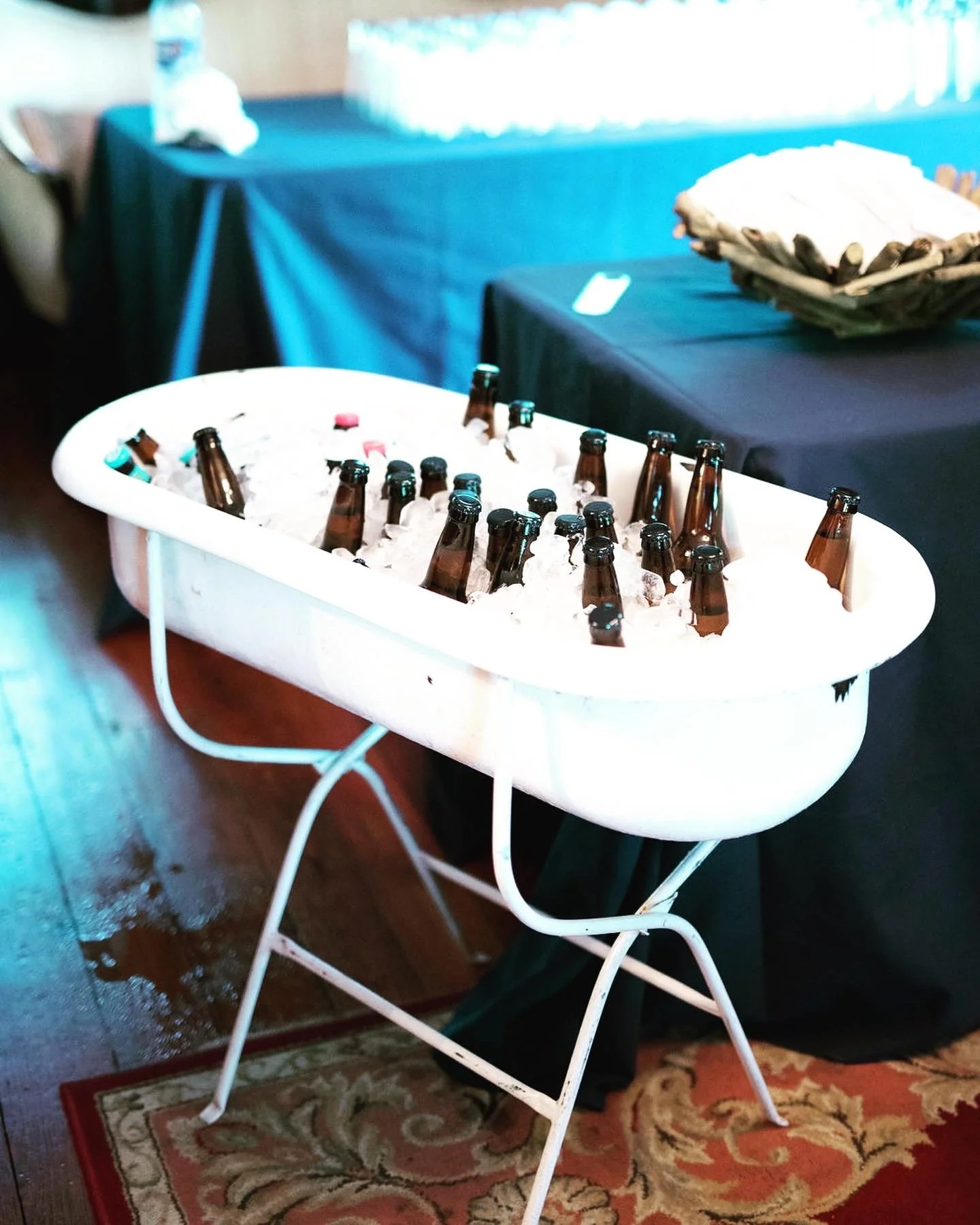 Bathtub filled with ice and beer bottles at an event.