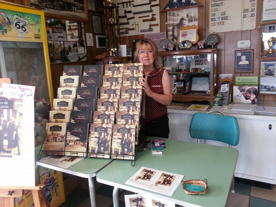 Chery with book display at Cozy Dog.jpg