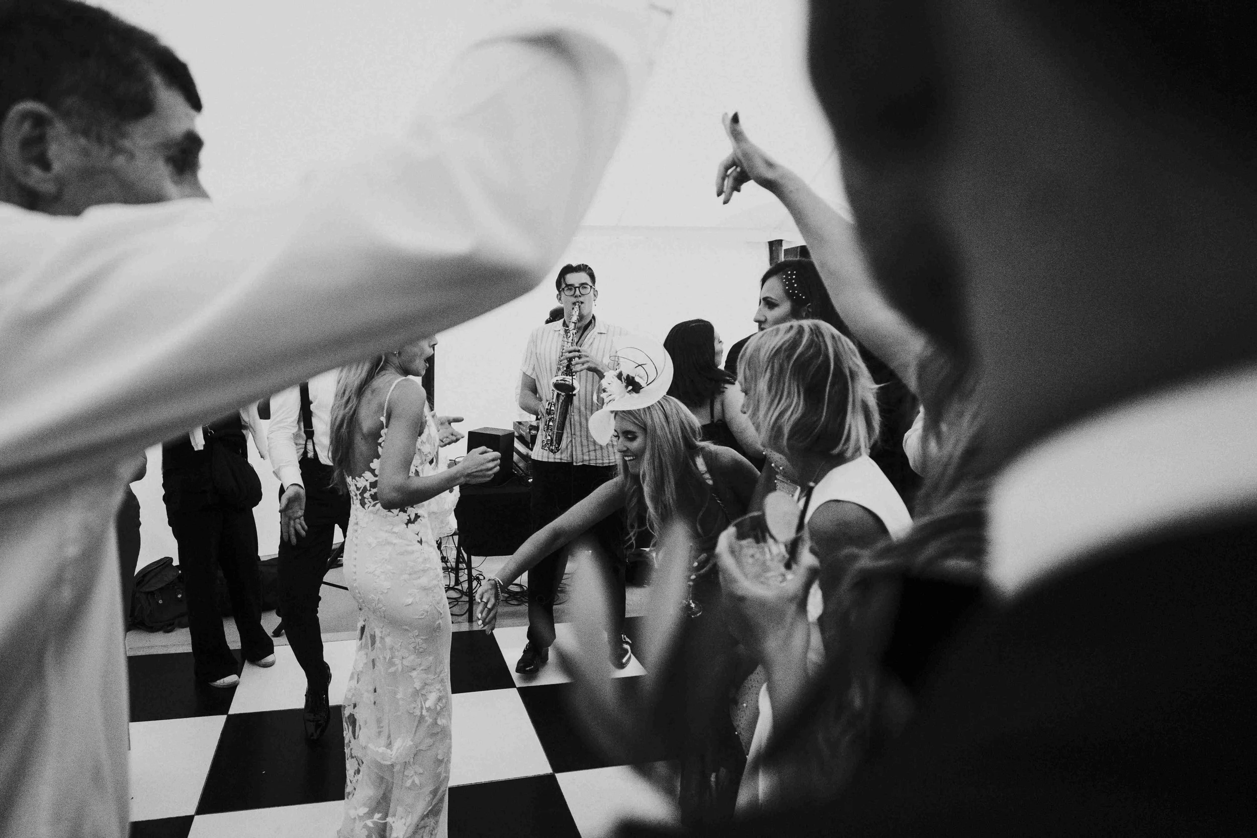 Guest dancing on the dance floor with the saxophone player in the background at the Halfmoon Farm Wedding in Rutland