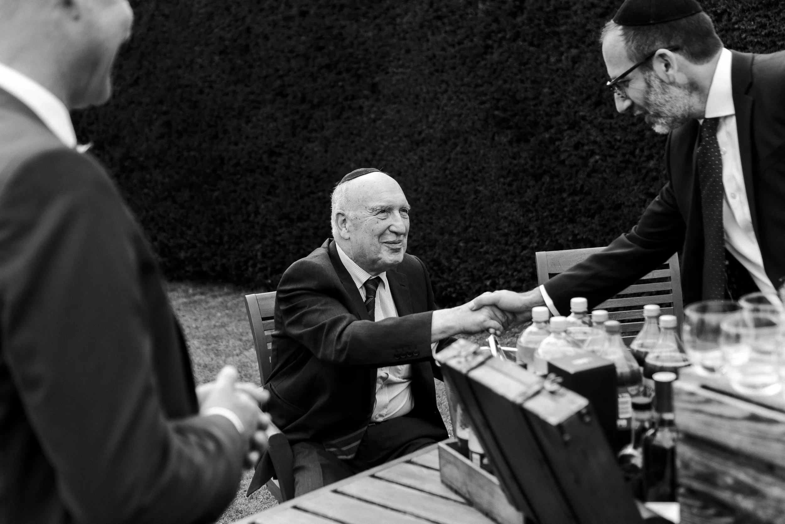 Guest shaking hands with another guest sitting down at a Micklefield Hall Wedding