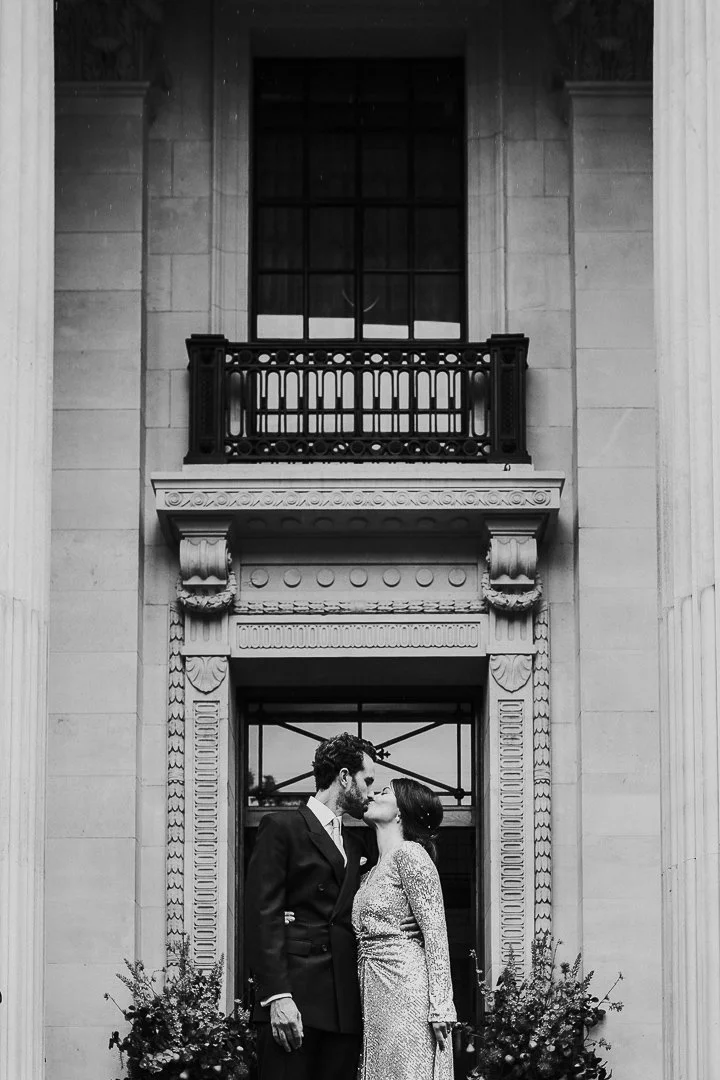 Wedding couple on steps outside kissing at the Old Marylebone Town Hall Wedding.