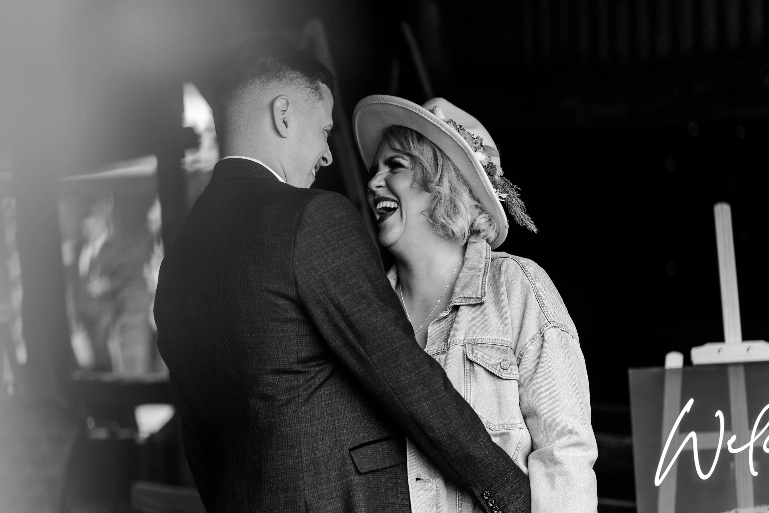 Wedding couple facing each other while the groom is holding the bride around her waist and both smiling at each other at a rhyse farm wedding