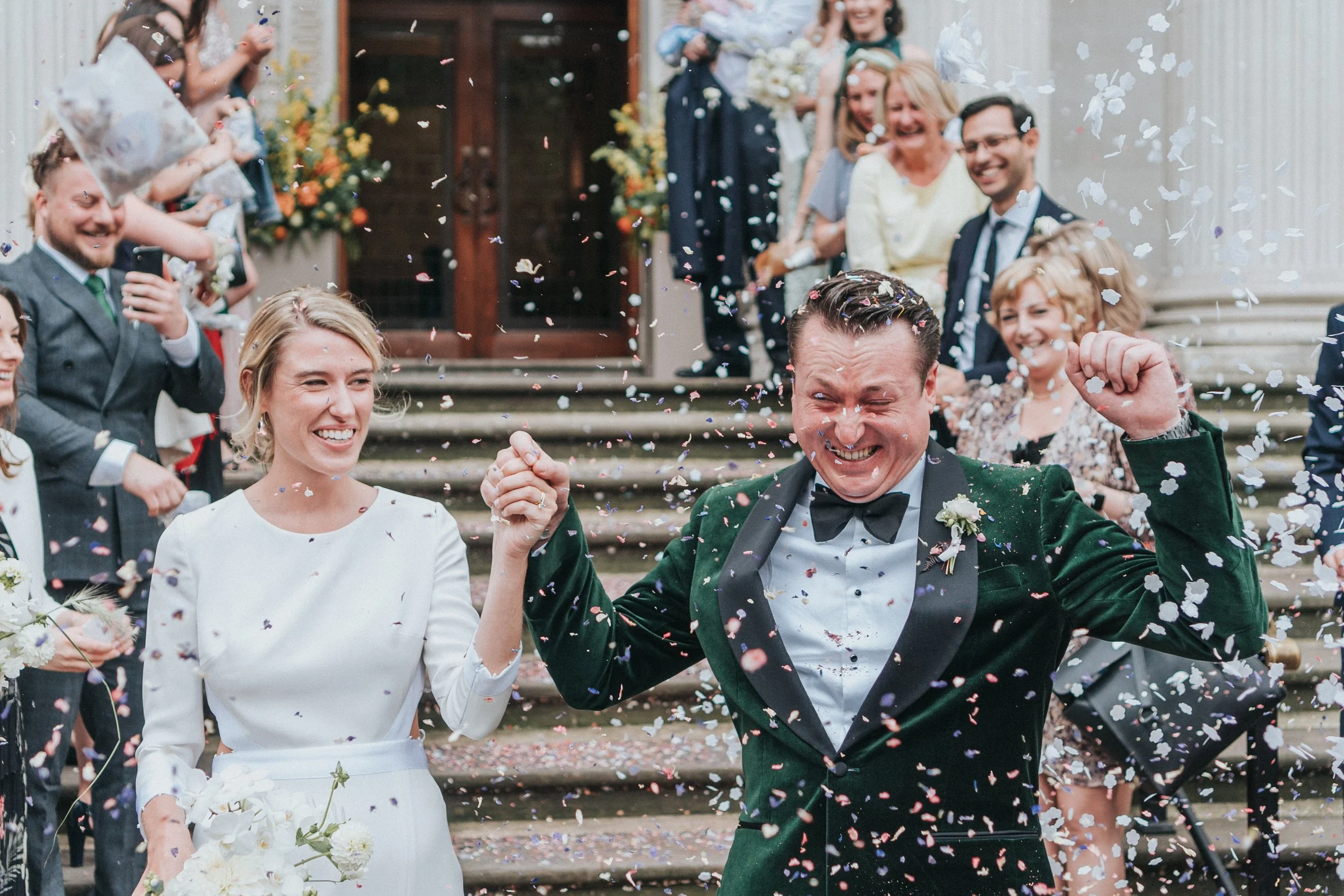 Wedding couple being showered with confetti with the Groom cheering at a Old Marylebone Town Hall Wedding