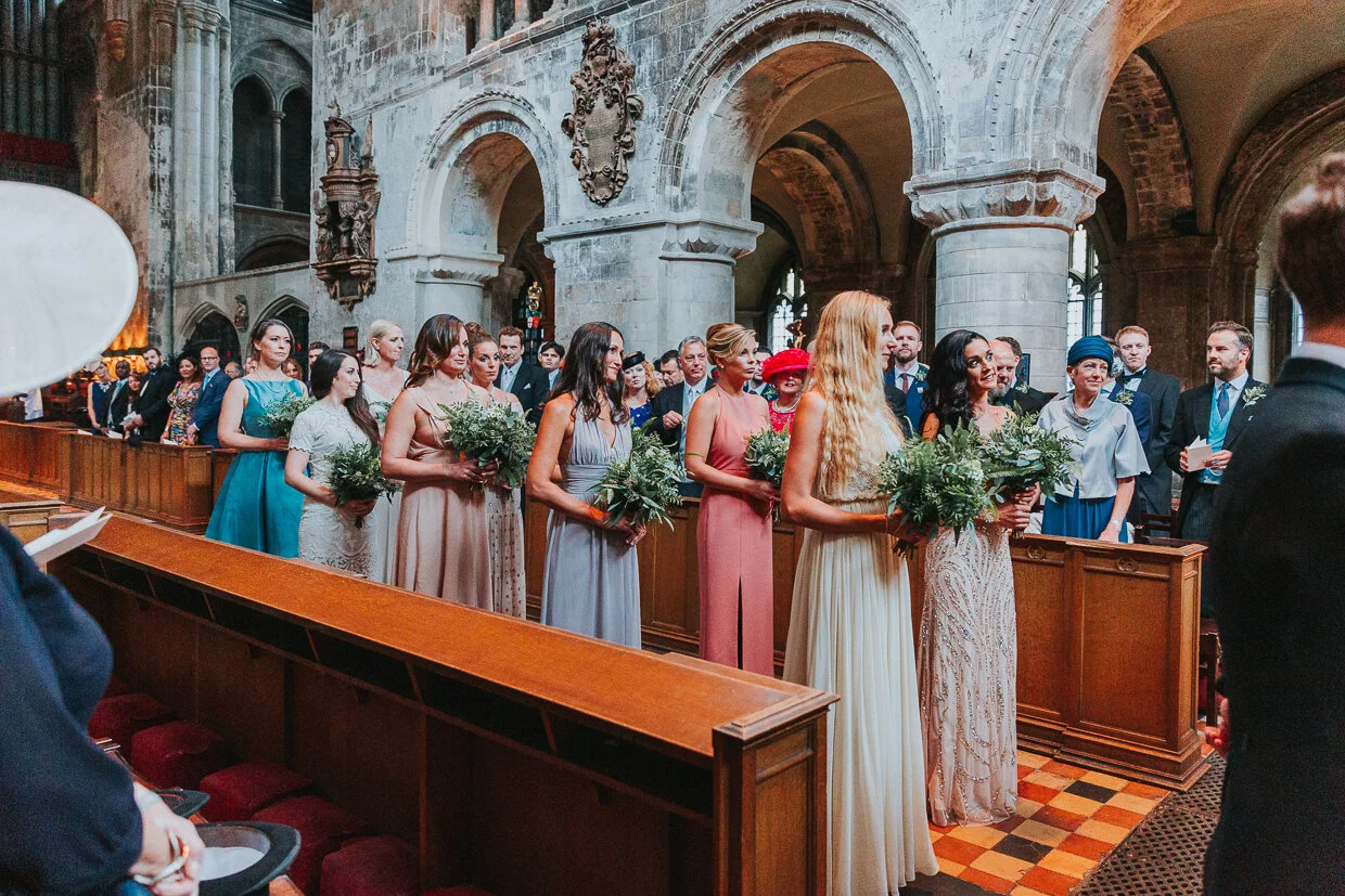 The procession of the Bridal Party walking down the aisle at St Bartholomew the Great church, Smithfield, for a City of London Wedding.