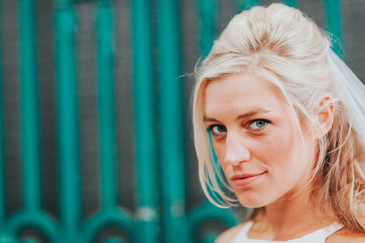 Bride looking at the camera with a slight smile at Smithfield Market for a City of London Wedding Photography.